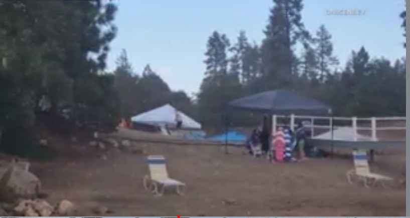 Survilance photo from Lake Arrowhead showing people packing up their belongings as the rain comes down. (OneScene)