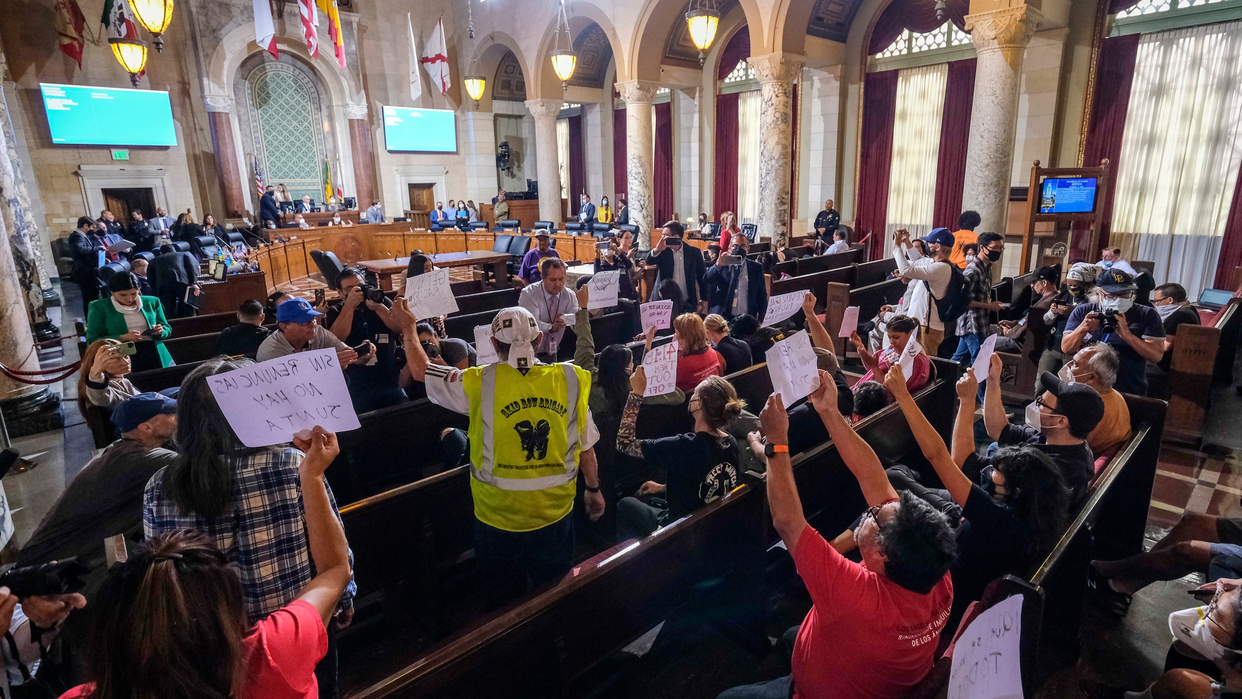 People hold signs and shout slogans as they protest before the cancellation of the Los Angeles City Council meeting Wednesday, Oct. 12, 2022 in Los Angeles. (AP Photo/Ringo H.W. Chiu)