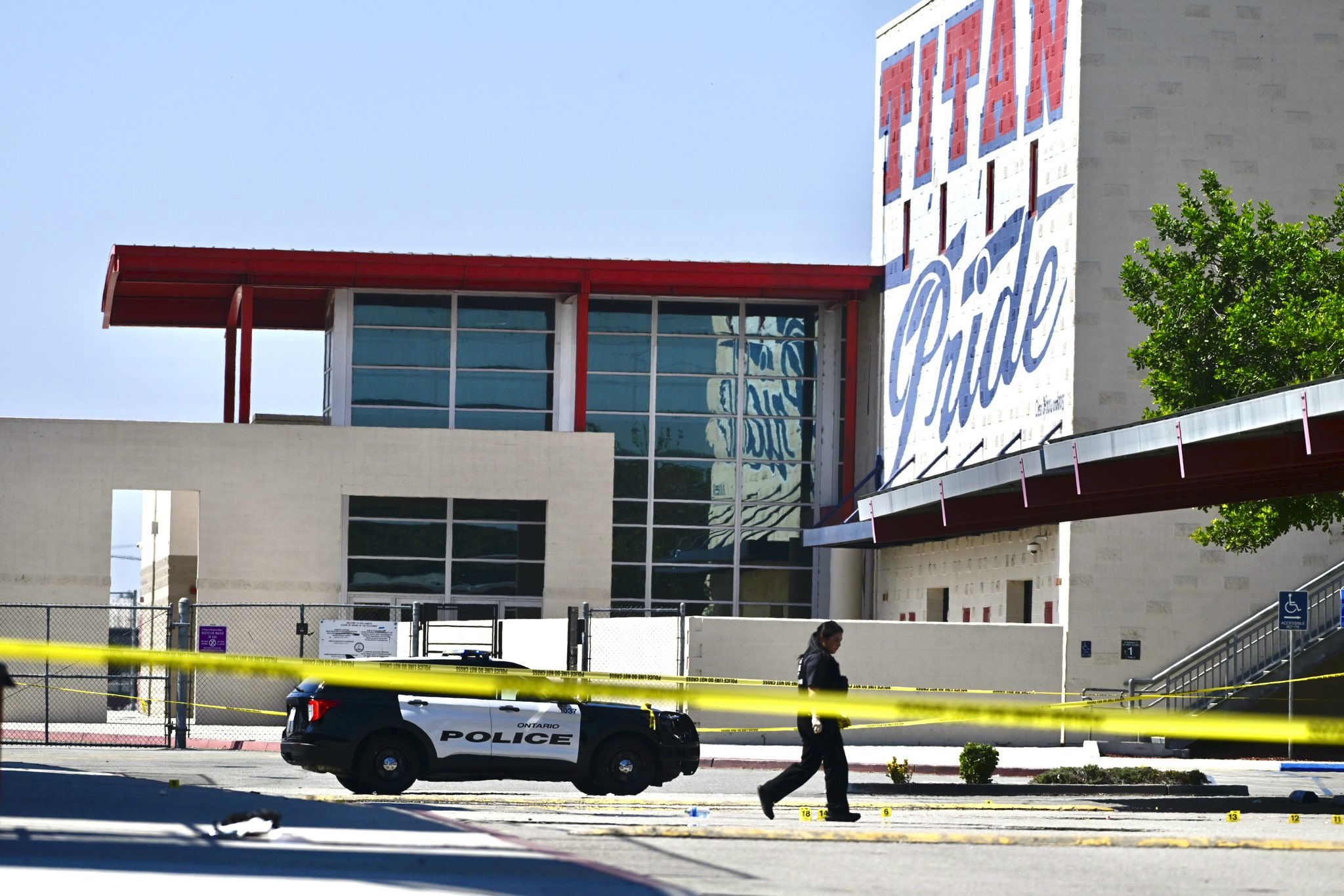 A police officer marks the scene of a shooting in Ontario, Calif., on Saturday, Oct. 1, 2022, after a person was shot several times at a youth football game at Colony High School. The game was not a school-sponsored event. (Watchara Phomicinda/The Orange County Register via AP)