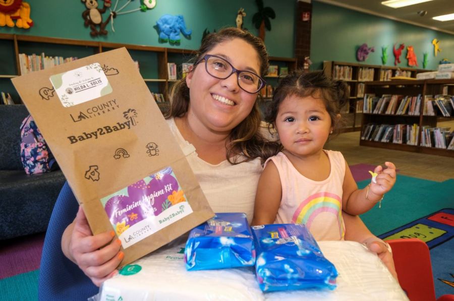 Mother and baby pictured on Oct. 28, 2022 receiving free diapers and menstrual products at select L.A. County Libraries.