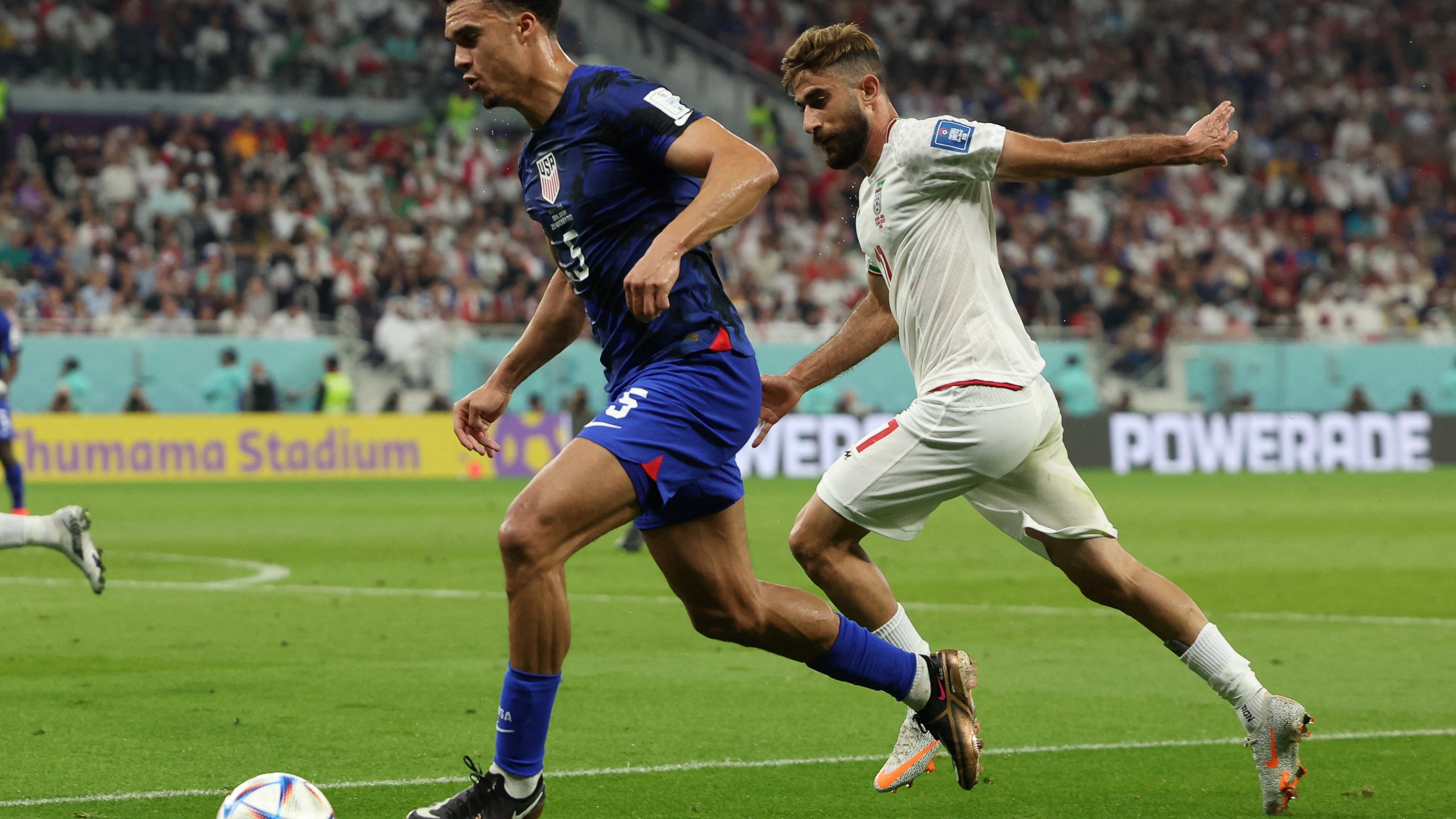 U.S. defender Antonee Robinson, left, fights for the ball with Iran's midfielder Ali Gholizadeh during the Qatar 2022 World Cup Group B football match between Iran and U.S. at the Al-Thumama Stadium in Doha on Nov. 29, 2022. (Fadel Senna / AFP via Getty Images)