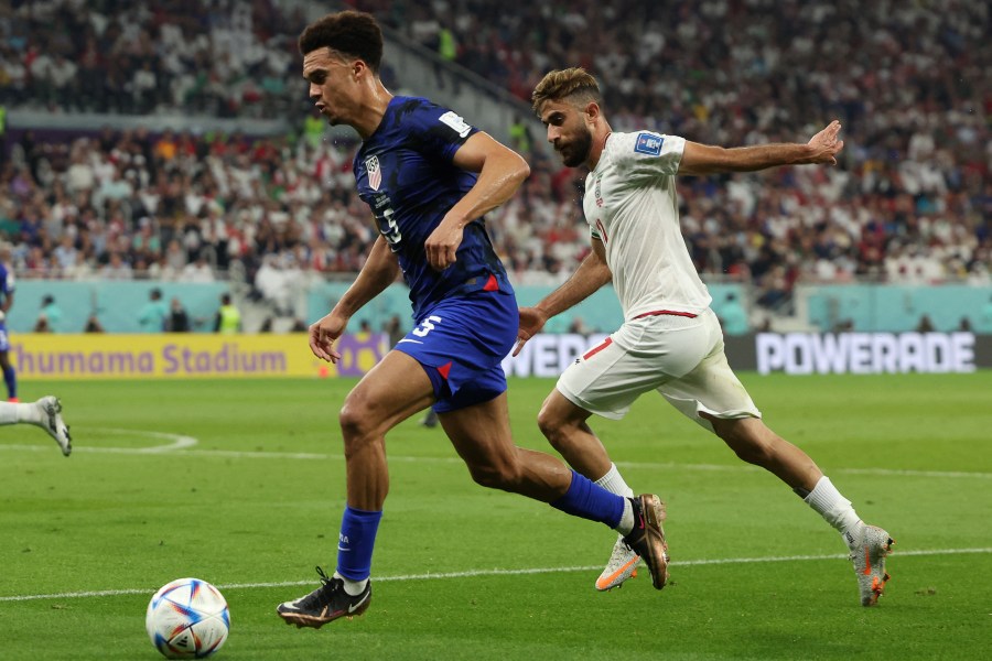 U.S. defender Antonee Robinson, left, fights for the ball with Iran's midfielder Ali Gholizadeh during the Qatar 2022 World Cup Group B football match between Iran and U.S. at the Al-Thumama Stadium in Doha on Nov. 29, 2022. (Fadel Senna / AFP via Getty Images)