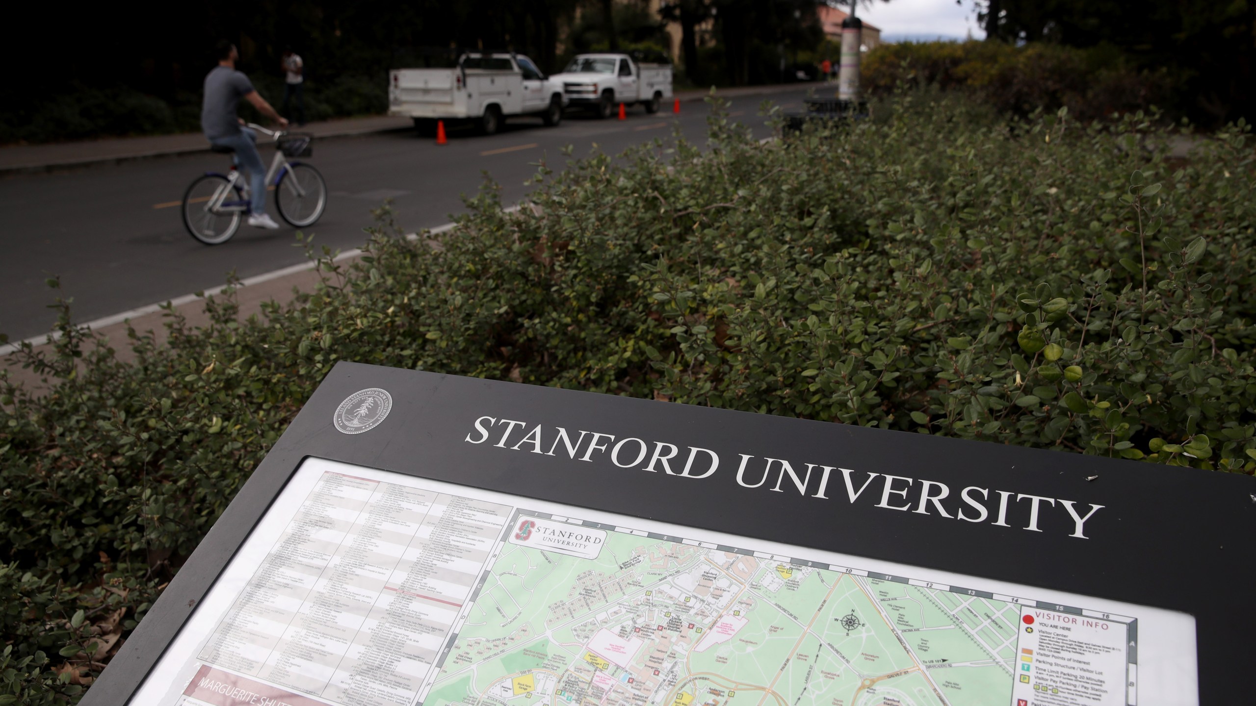 A cyclist rides by a map of the Stanford University campus on March 12, 2019 in Stanford, California (Justin Sullivan/Getty Images)