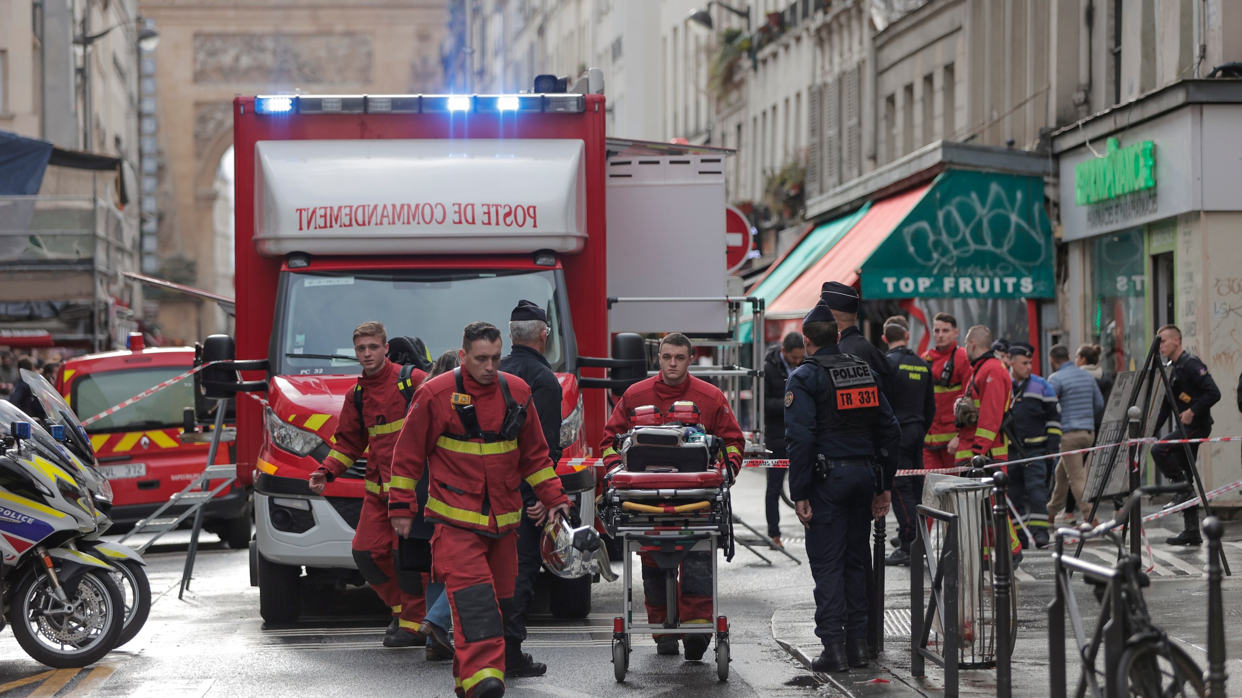 Fire brigade medics work on the scene where a shooting took place in Paris, Friday, Dec. 23, 2022. aMultiple people have been wounded and one person arrested after a shooting in central Paris on Friday, authorities said. Police cordoned off the area in the 10th arrondissement of Paris and the Paris police department warned people to stay away from the area. It said one person was arrested, without providing details. (AP Photo/Lewis Joly)