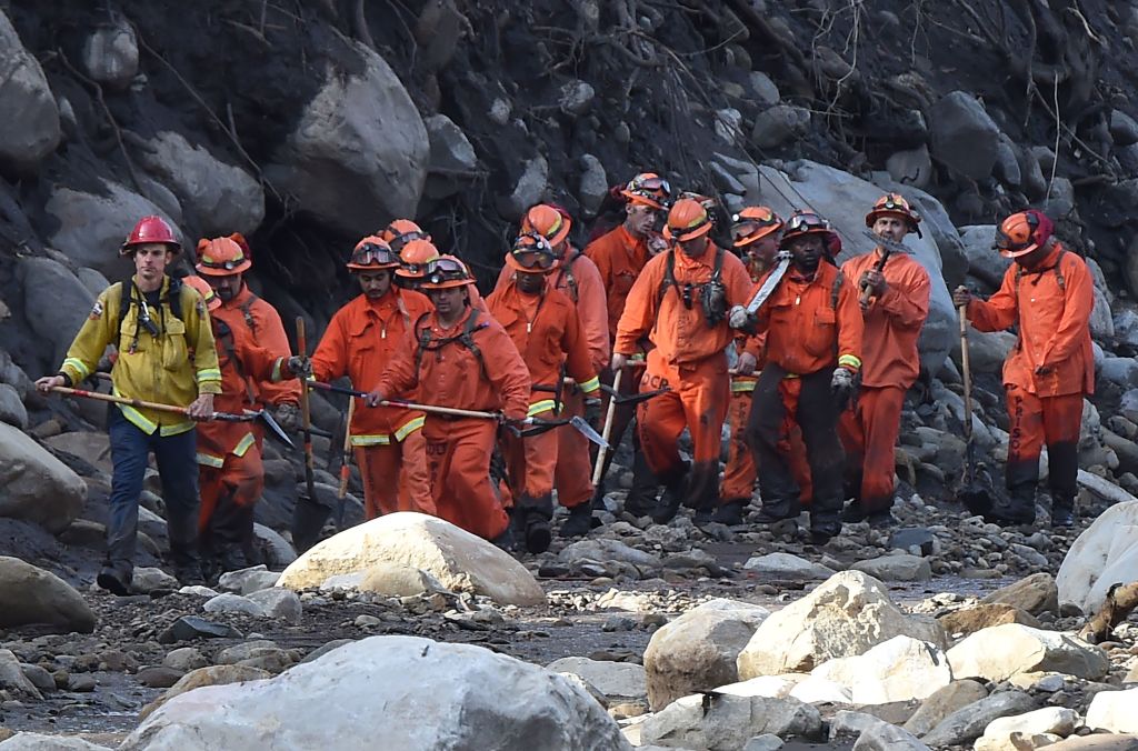 A Cal Fire inmate crew hikes down a creek while clearing debris to aid in the search for survivors of a massive mudflow in Montecito, California, January 10, 2018.