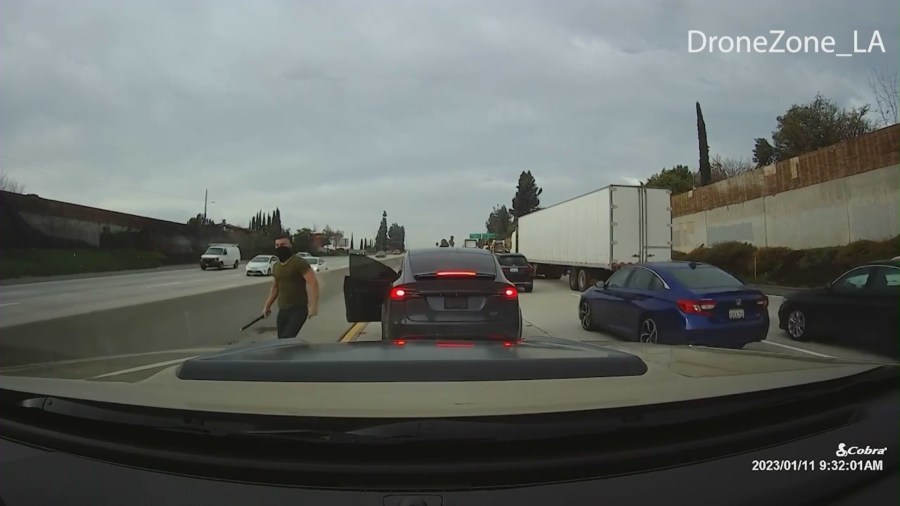 Suspect seen getting out of a Tesla SUV and attacking a victim with a large pipe on a SoCal freeway. (DroneZone_LA)