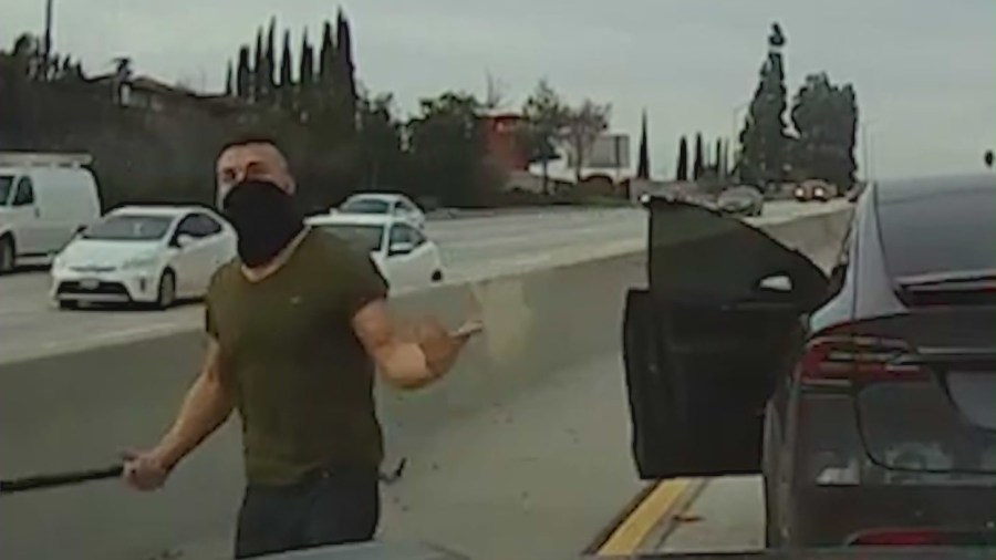 Suspect seen getting out of a Tesla SUV and attacking a victim with a large pipe on a SoCal freeway. (DroneZone_LA)