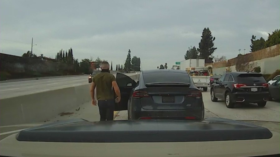 Suspect seen getting out of a Tesla SUV and attacking a victim with a large pipe on a SoCal freeway. (DroneZone_LA)