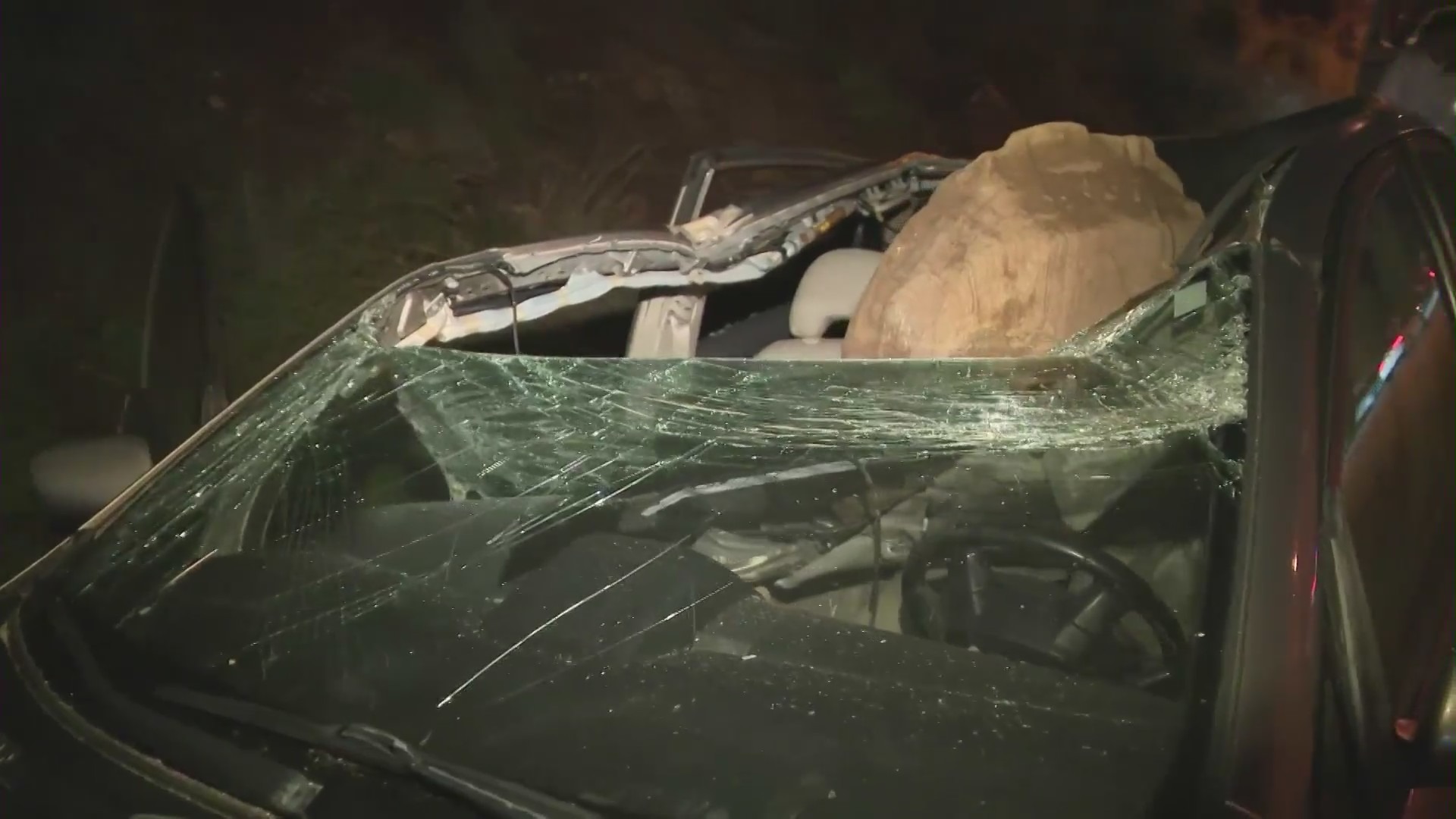 The aftermath of a giant boulder crushing a car as it tumbled off a Malibu hillside on Jan. 10, 2023. (KTLA)