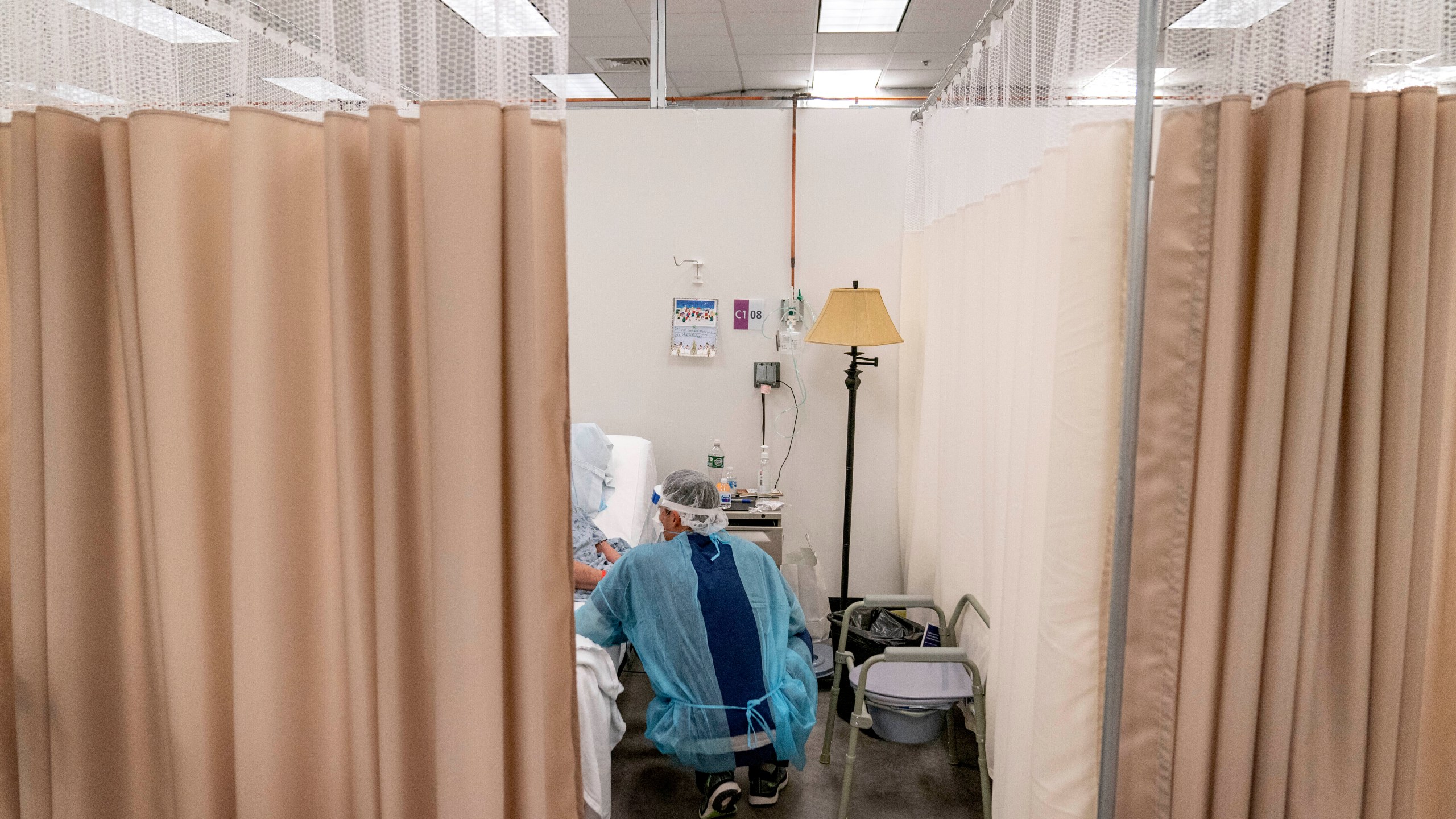 A physical therapist works with a patient at a field hospital operated by Care New England in Cranston, R.I, Dec. 14, 2020. Roughly 84 million people are covered by Medicaid, the government-sponsored program that's grown by 20 million people since January 2020. (AP Photo/David Goldman, File)