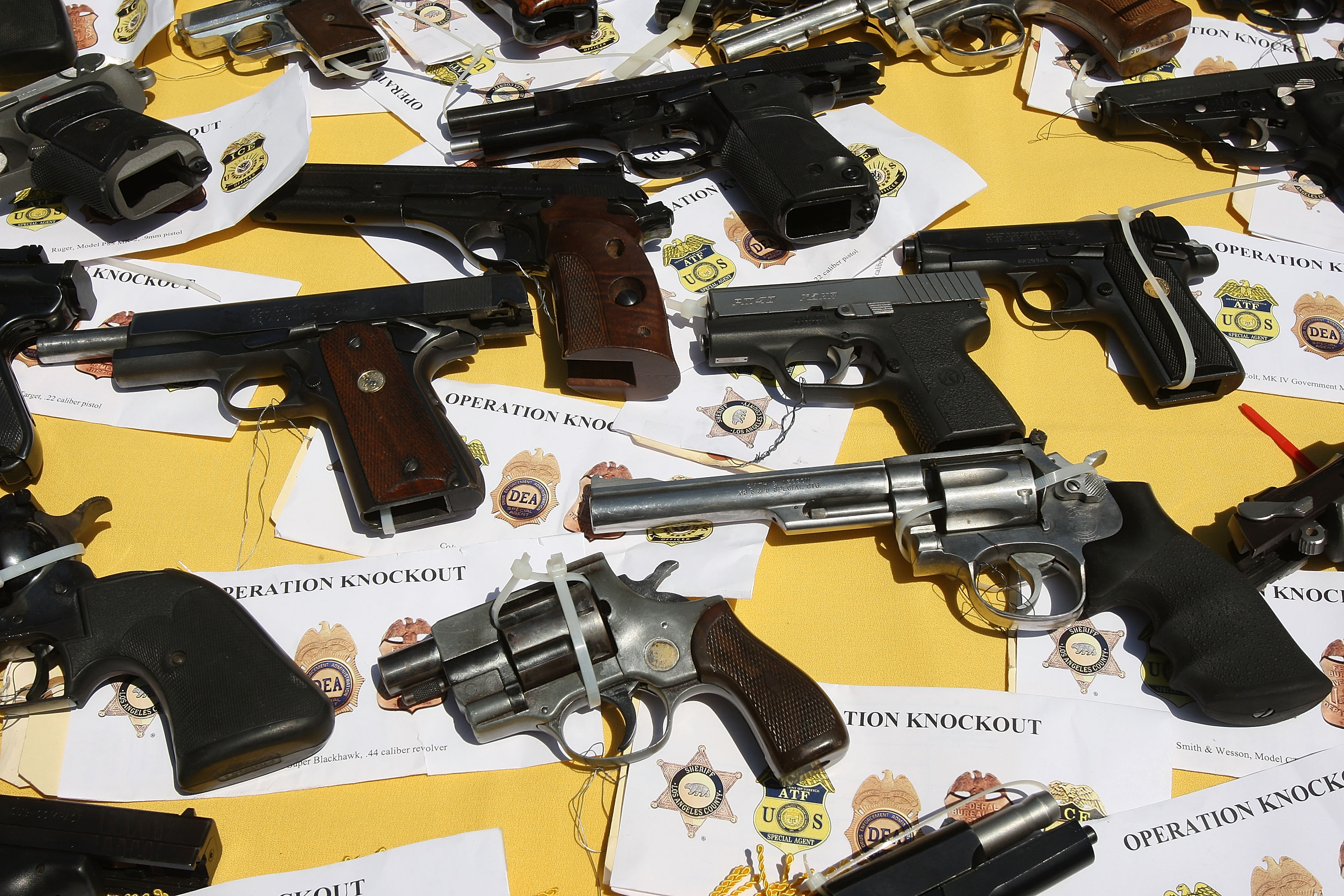 Some of about 125 weapons confiscated in a gang takedown are displayed at a press conference on May 21, 2009 in the Los Angeles-area community of Lakewood, California. (Photo by David McNew/Getty Images)