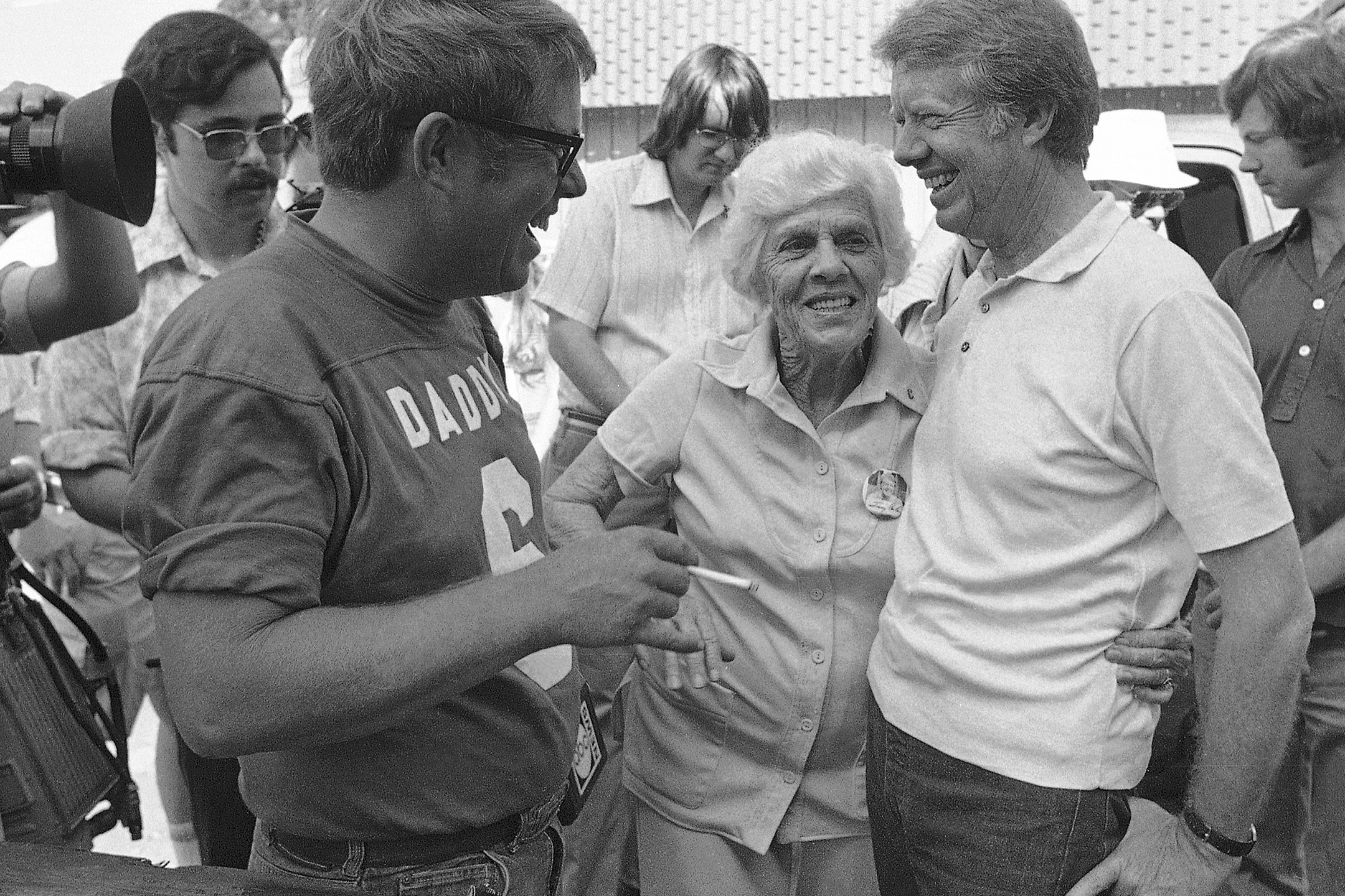 Lillian Carter is flanked by her sons Jimmy, right, and Billy as she met them down at Billy's gas station, where the Carters and neighbors cleaned fish prior to a town cookout, June 26, 1976. (Mark Foley/Associated Press)