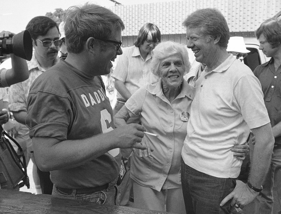 Lillian Carter is flanked by her sons Jimmy, right, and Billy as she met them down at Billy's gas station, where the Carters and neighbors cleaned fish prior to a town cookout, June 26, 1976. (Mark Foley/Associated Press)