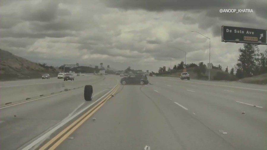 Dash-cam footage from a Tesla captured the moment a vehicle on the 118 Freeway in Chatsworth ran over a tire that had just come off a nearby pickup truck, launching the car into a midair spin on Mar. 23, 2023. (Anoop Khatra)