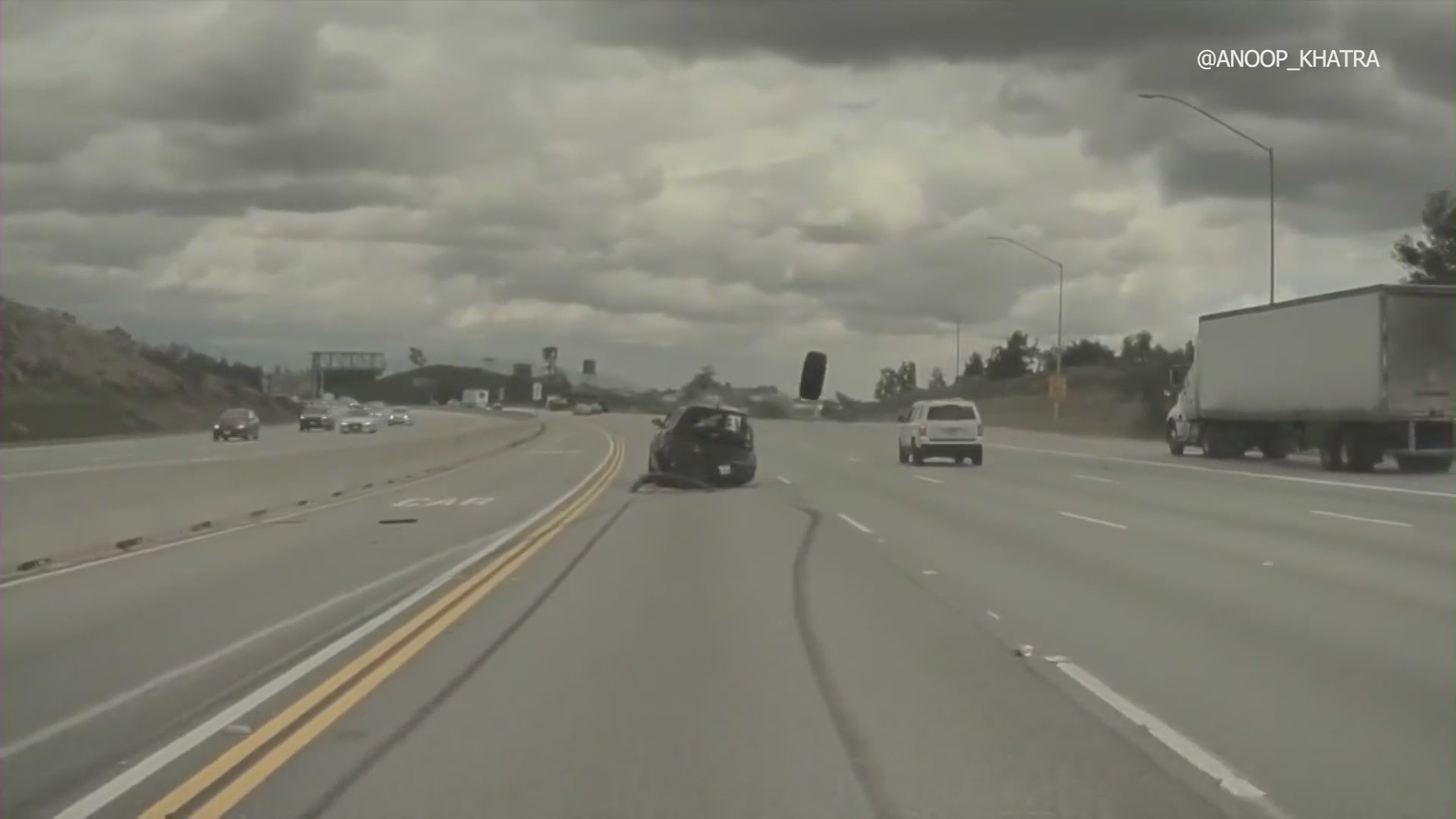 Dash-cam footage from a Tesla captured the moment a vehicle on the 118 Freeway in Chatsworth ran over a tire that had just come off a nearby pickup truck, launching the car into a midair spin on Mar. 23, 2023. (Anoop Khatra)