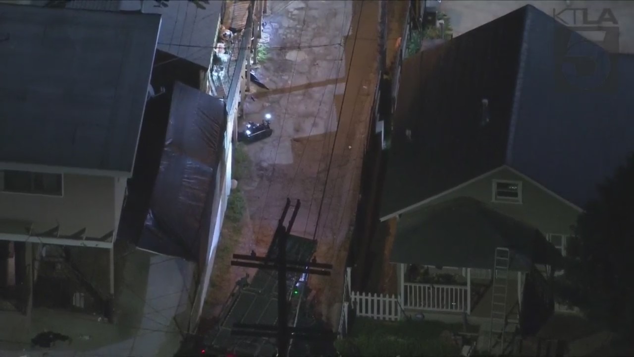 An LAPD robot sits in an alleyway next to a home where a suspect was barricaded following a shootout with police on March 8, 2023. (KTLA)