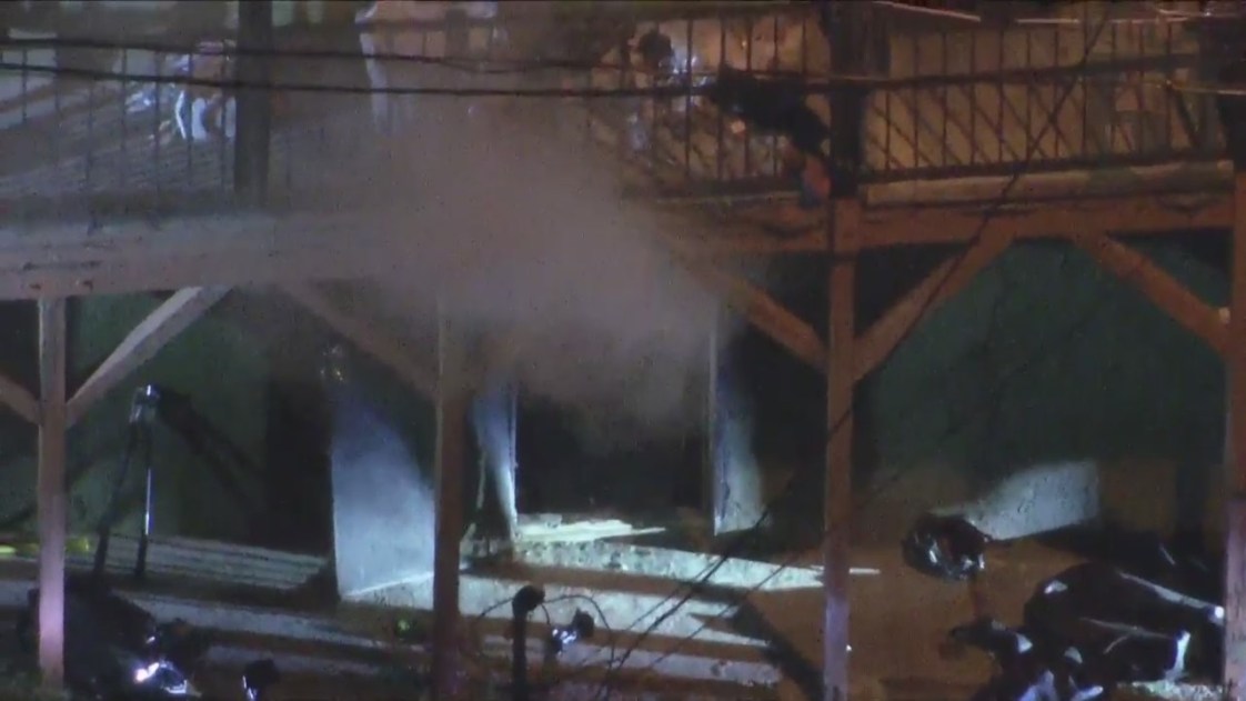 Tear gas streams from a home in Lincoln Heights where a suspect was barricaded following a shootout with police on March 8, 2023. (KTLA)