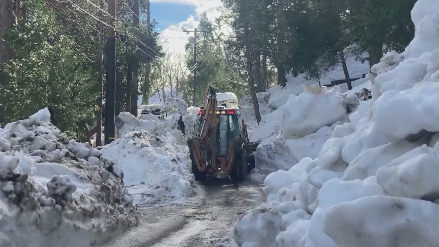 Locals and emergency crews dig out homes and roads after a historic winter snowstorm in San Bernardino County mountain communities. (KTLA)