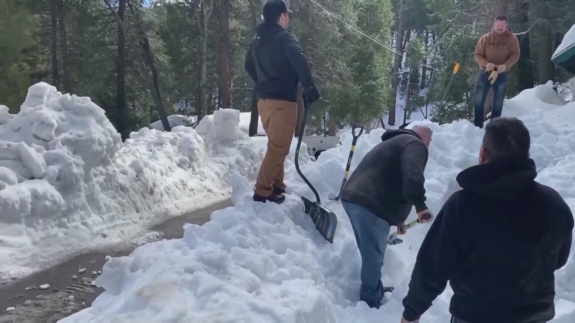 Mountain community residents digging out homes and roads after a historic winter snowstorm in San Bernardino County. (KTLA)