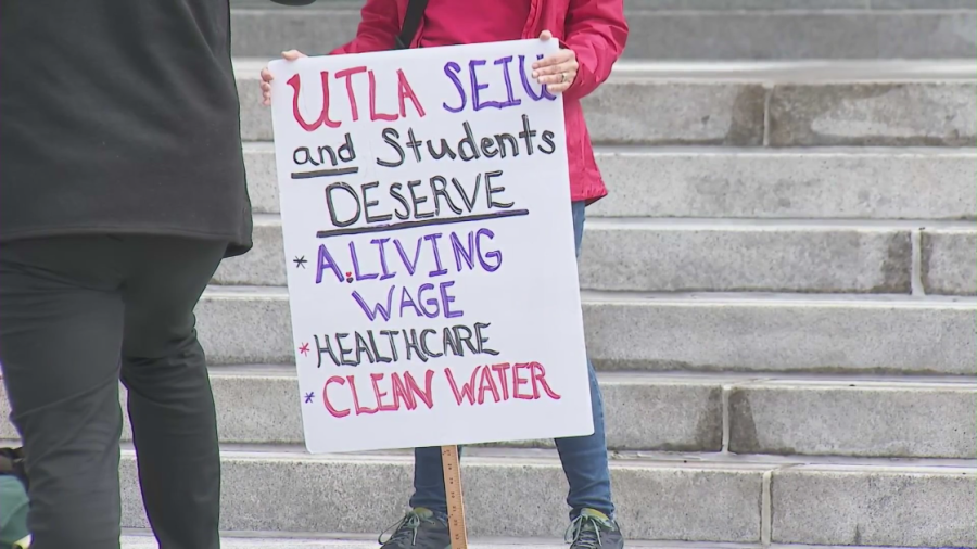 A demonstrator holds up a sign outside Los Angeles City Hall before a rally announcing a possible LAUSD workers strike on March 15, 2023. (KTLA)