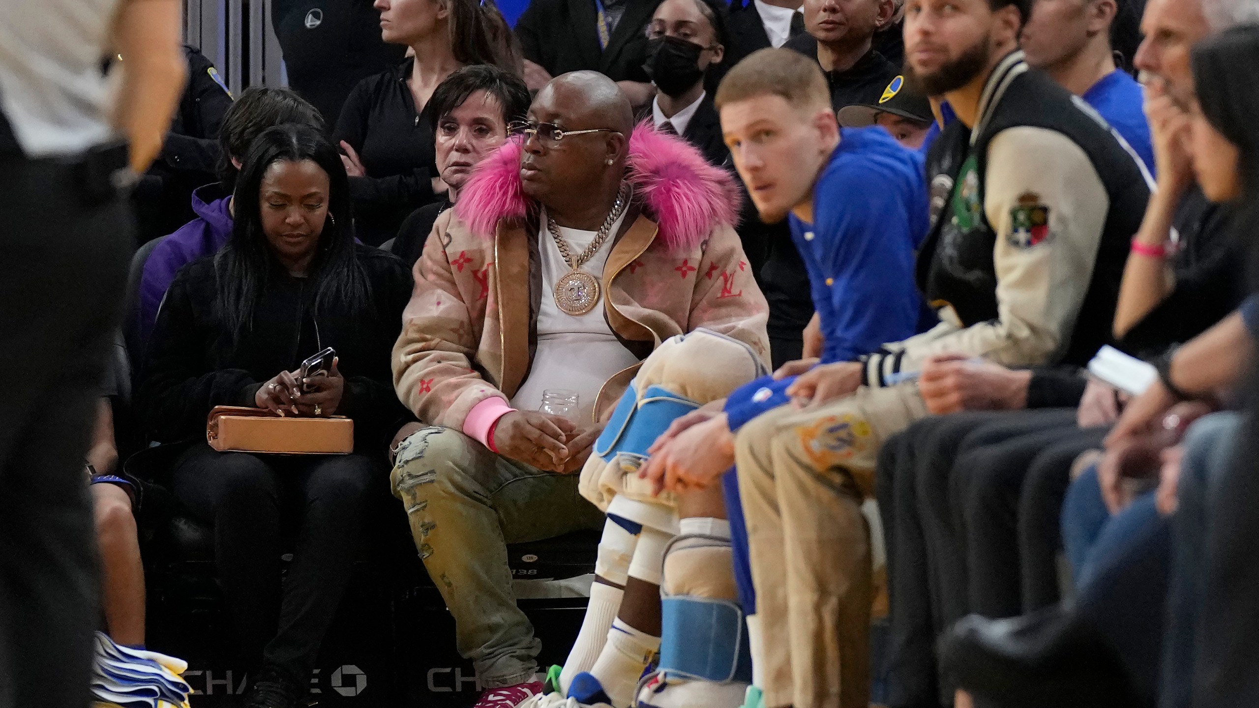 E-40, middle, watches during an NBA basketball game between the Golden State Warriors and the Portland Trail Blazers in San Francisco, Dec. 30, 2022. (AP Photo/Jeff Chiu, File)