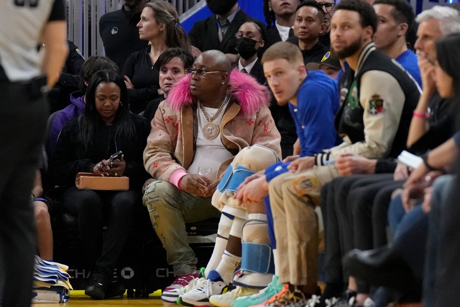 E-40, middle, watches during an NBA basketball game between the Golden State Warriors and the Portland Trail Blazers in San Francisco, Dec. 30, 2022. (AP Photo/Jeff Chiu, File)