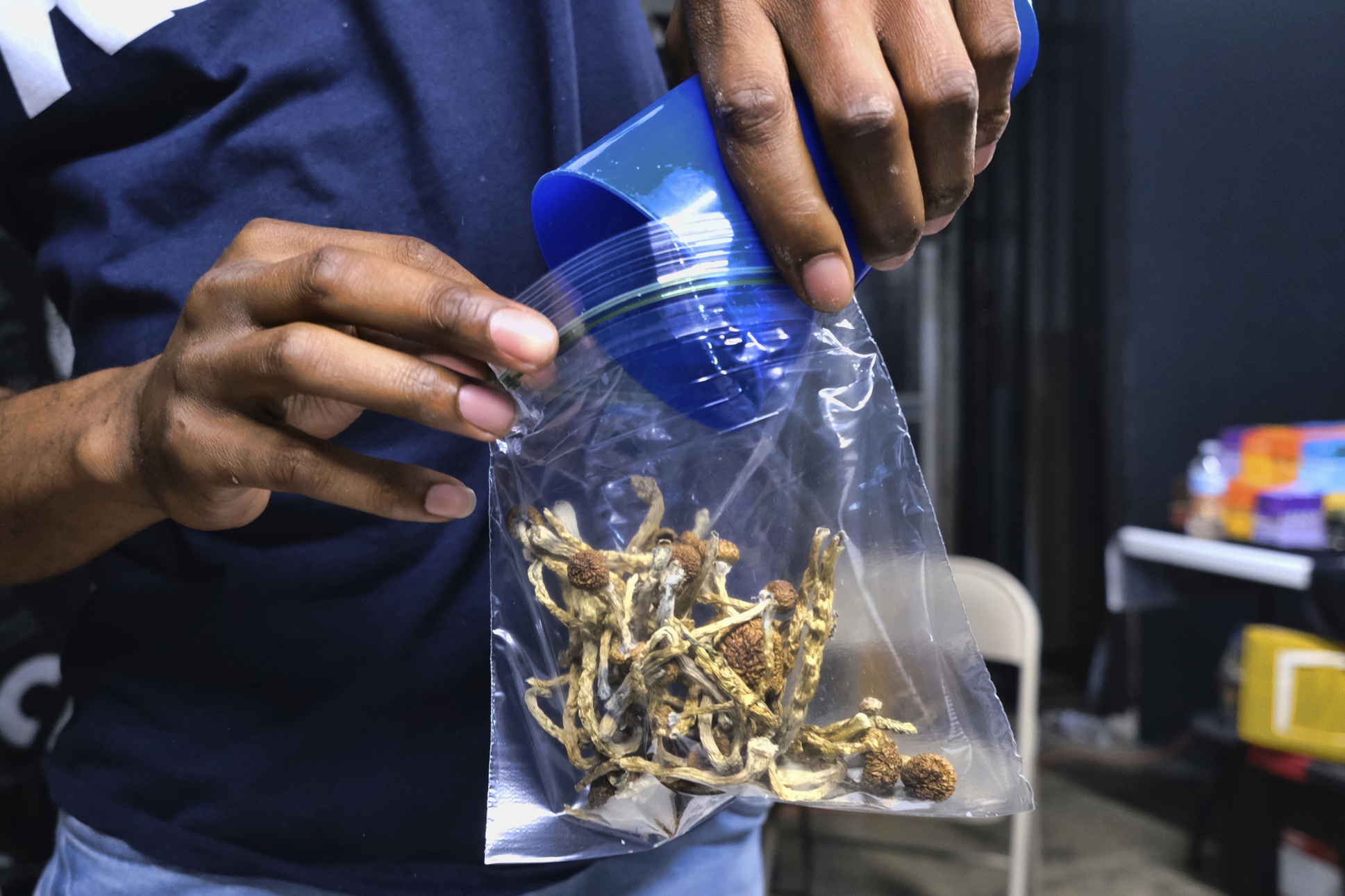 A vendor bags psilocybin mushrooms at a cannabis marketplace on May 24, 2019, in Los Angeles. (AP Photo/Richard Vogel, File)