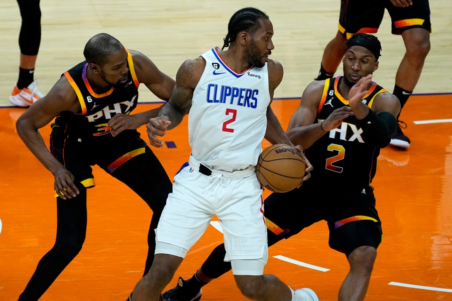 Los Angeles Clippers forward Kawhi Leonard (2) looks to pass under pressure from Phoenix Suns forward Josh Okogie (2) and forward Kevin Durant during the second half of Game 2 of a first-round NBA basketball playoff series, Tuesday, April 18, 2023, in Phoenix. (AP Photo/Matt York)