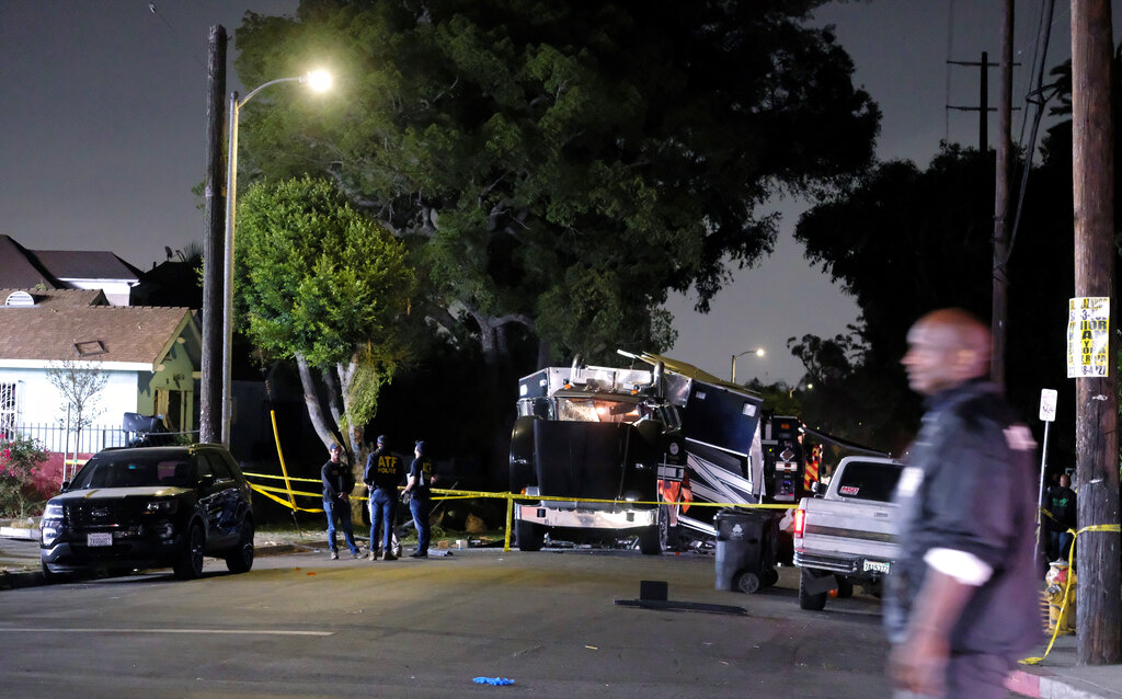 The remains of an armored Los Angeles Police Department tractor-trailer are seen after fireworks exploded Wednesday evening, June 30, 2021. A cache of illegal fireworks seized at a South Los Angeles home exploded, damaging nearby homes and cars and injuring more than a dozen people, authorities said. (AP Photo/Ringo H.W. Chiu)