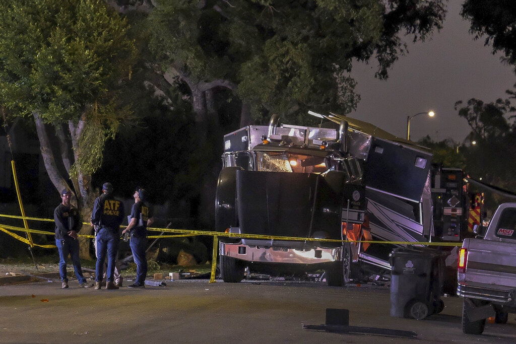 The remains of an armored Los Angeles Police Department tractor-trailer are seen after fireworks exploded Wednesday evening, June 30, 2021. A cache of illegal fireworks seized at a South Los Angeles home exploded, damaging nearby homes and cars and causing injuries, authorities said. (AP Photo/Ringo H.W. Chiu)