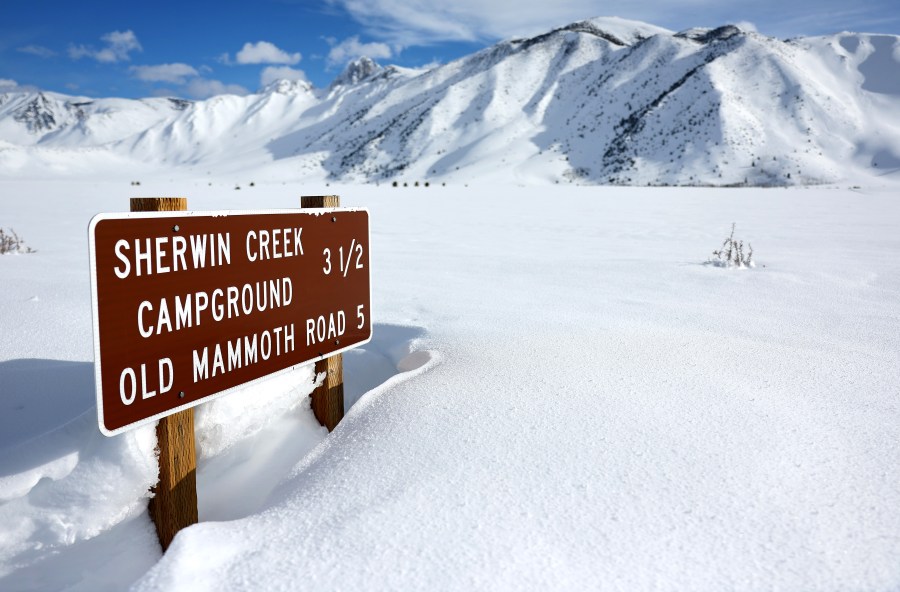 A road sign is partially buried in snow in the Sierra Nevada mountains after yet another storm system brought heavy snowfall to higher elevations further raising the snowpack on March 30, 2023 near Mammoth Lakes, California. (Mario Tama/Getty Images)