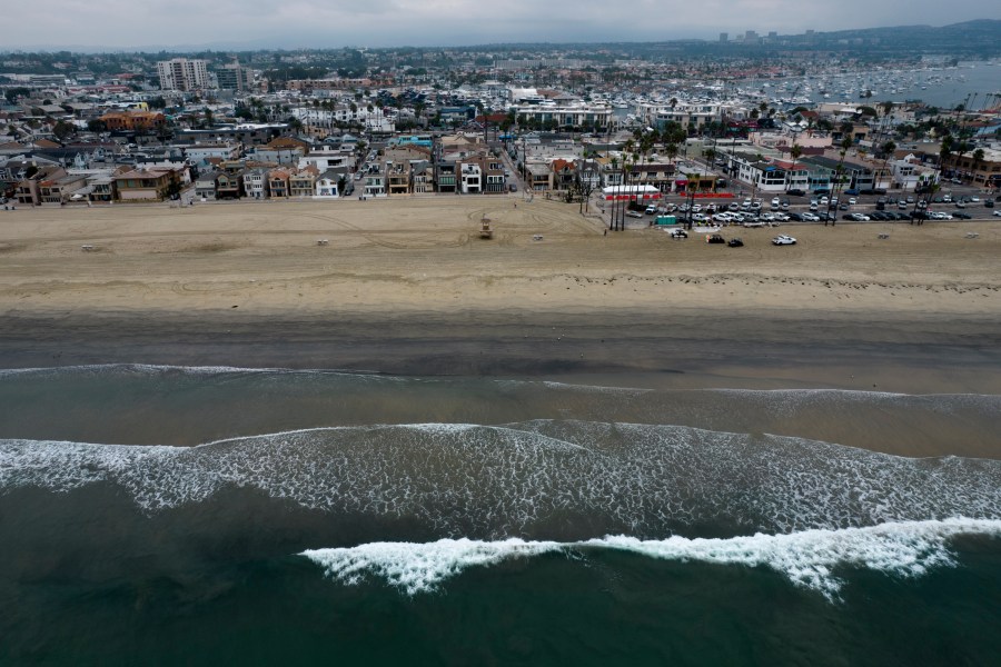 This aerial image taken with a drone shows the closed beach after oil washed up in Newport Beach, Calif., on Oct. 7, 2021. An offshore pipeline involved in a 2021 oil spill that fouled Southern California beaches is being put back in service, the operator said. Amplify Energy Corp. said Monday, April 11, 2023, that it received approval from federal regulatory agencies to restart operations and last weekend began the process of filling the pipeline, which is expected to take about two weeks. (AP Photo/Ringo H.W. Chiu, File)