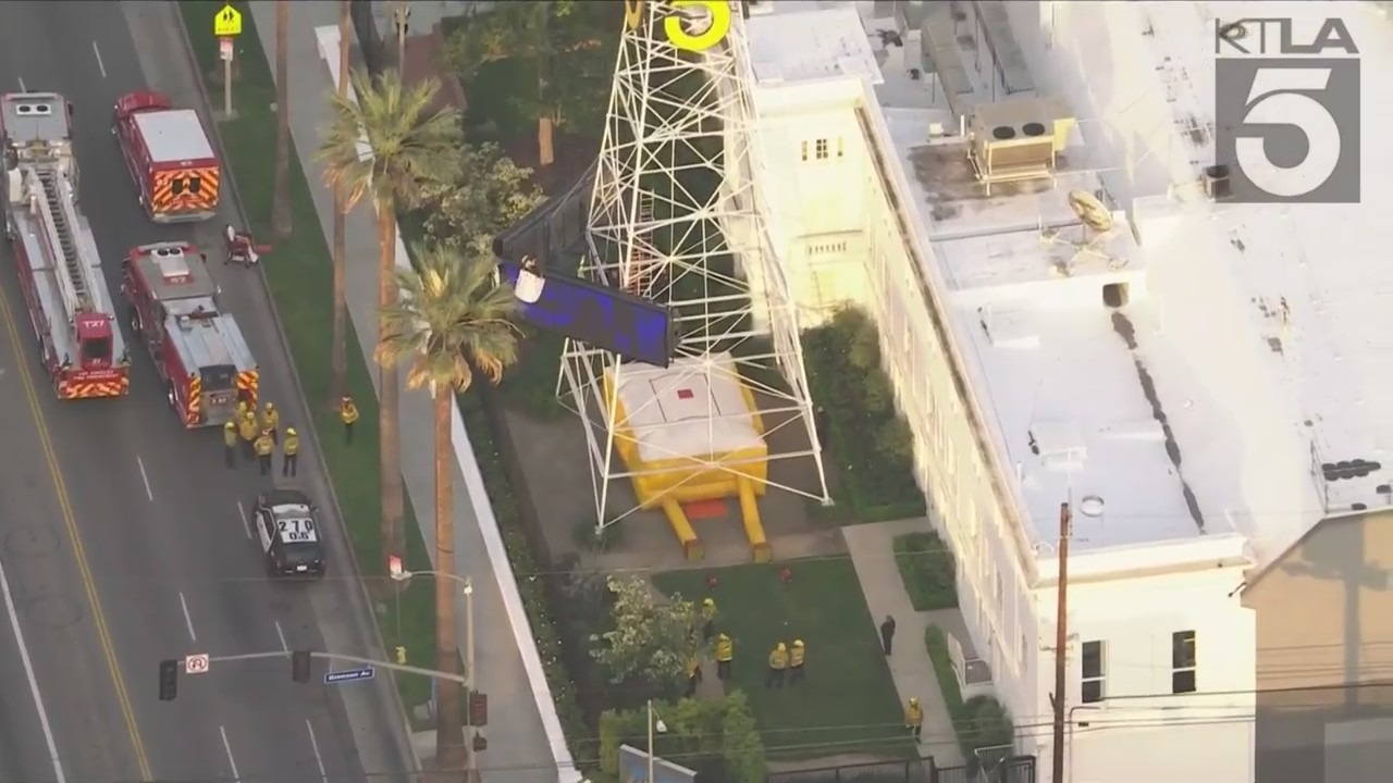 A man was seen climbing the KTLA 5 radio tower in Hollywood while holding a sign that read, “Free Billie Eilish” as authorities worked to remove him on April 25, 2023. (KTLA)