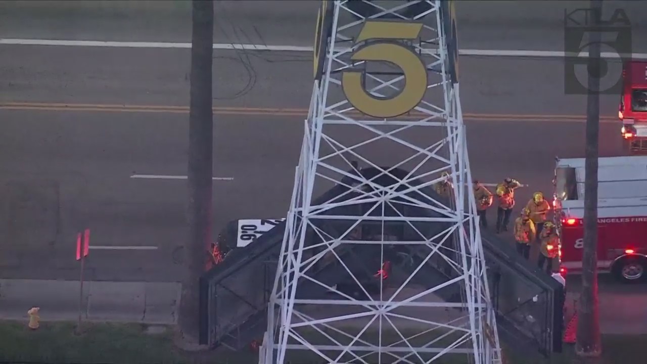 A man was seen climbing the KTLA 5 radio tower in Hollywood while holding a sign that read, “Free Billie Eilish” as authorities worked to remove him on April 25, 2023. (KTLA)