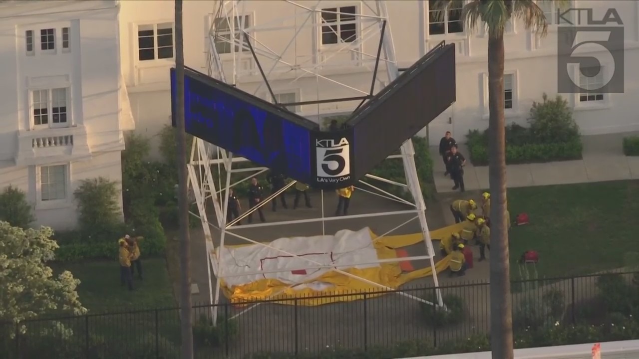 A man was seen climbing the KTLA 5 radio tower in Hollywood while holding a sign that read, “Free Billie Eilish” as authorities worked to remove him on April 25, 2023. (KTLA)