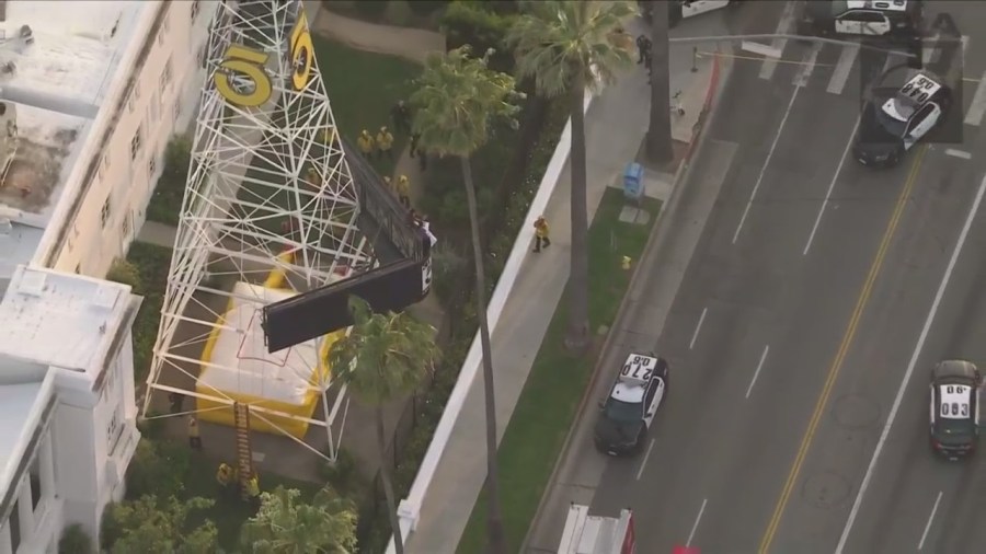 A man was seen climbing the KTLA 5 radio tower in Hollywood while holding a sign that read, “Free Billie Eilish” as authorities worked to remove him on April 25, 2023. (KTLA)