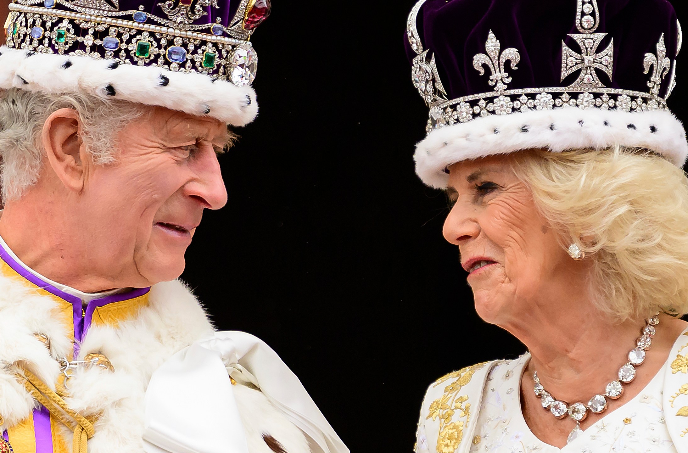 Britain's King Charles III and Queen Camilla look at each other as they stand on the balcony of the Buckingham Palace after their coronation, in London, Saturday, May 6, 2023. (Leon Neal/Pool Photo via AP)