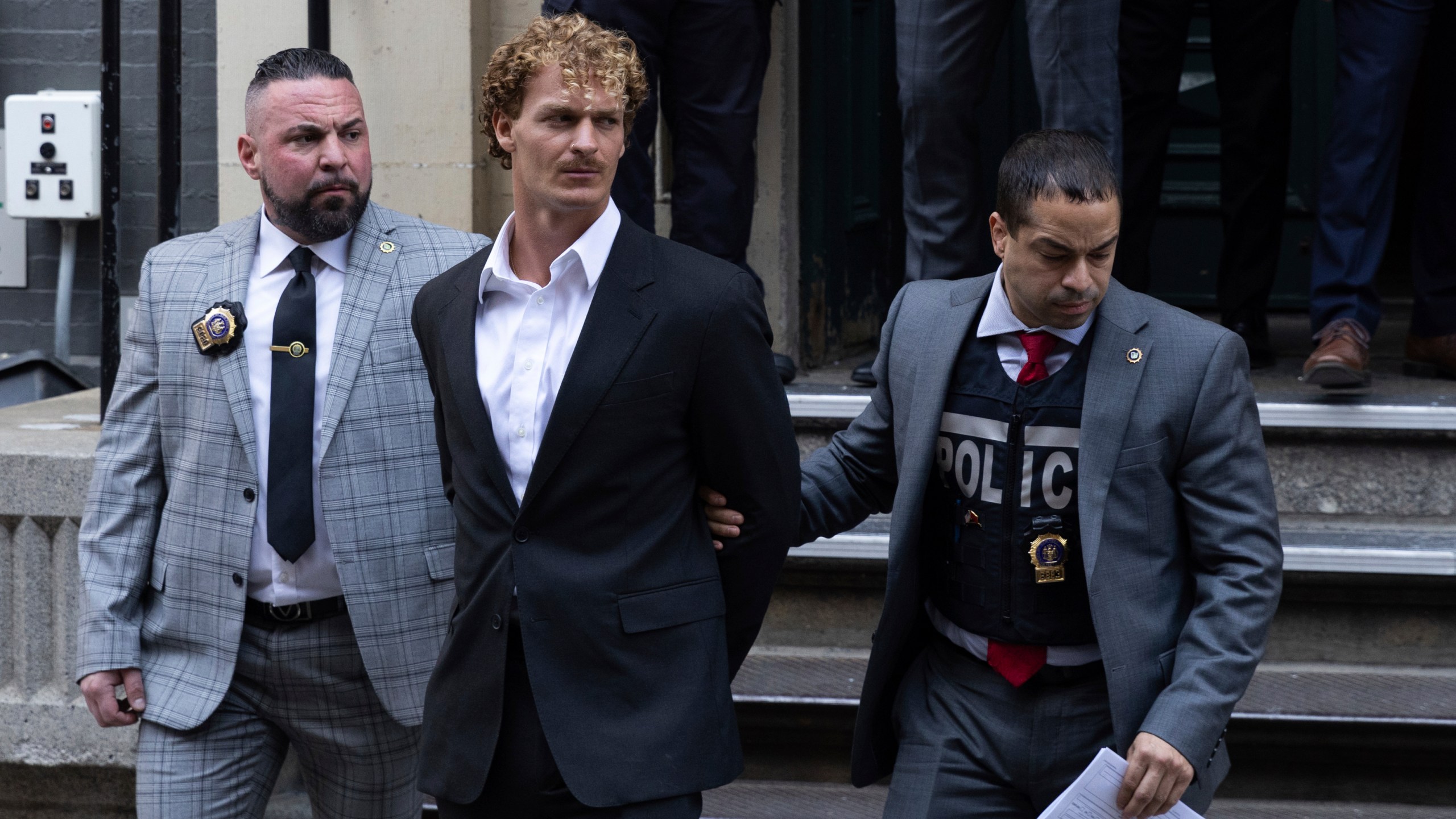 Daniel Penny, center, is walked by New York Police Department detectives detectives out of the 5th Precinct on Friday, May. 12, 2023 in New York. Manhattan prosecutors announced Thursday they would bring the criminal charge against Penny, 24, a U.S. Marine Corps veteran, in the May 1 death of 30-year-old Jordan Neely. (AP Photo/Jeenah Moon)