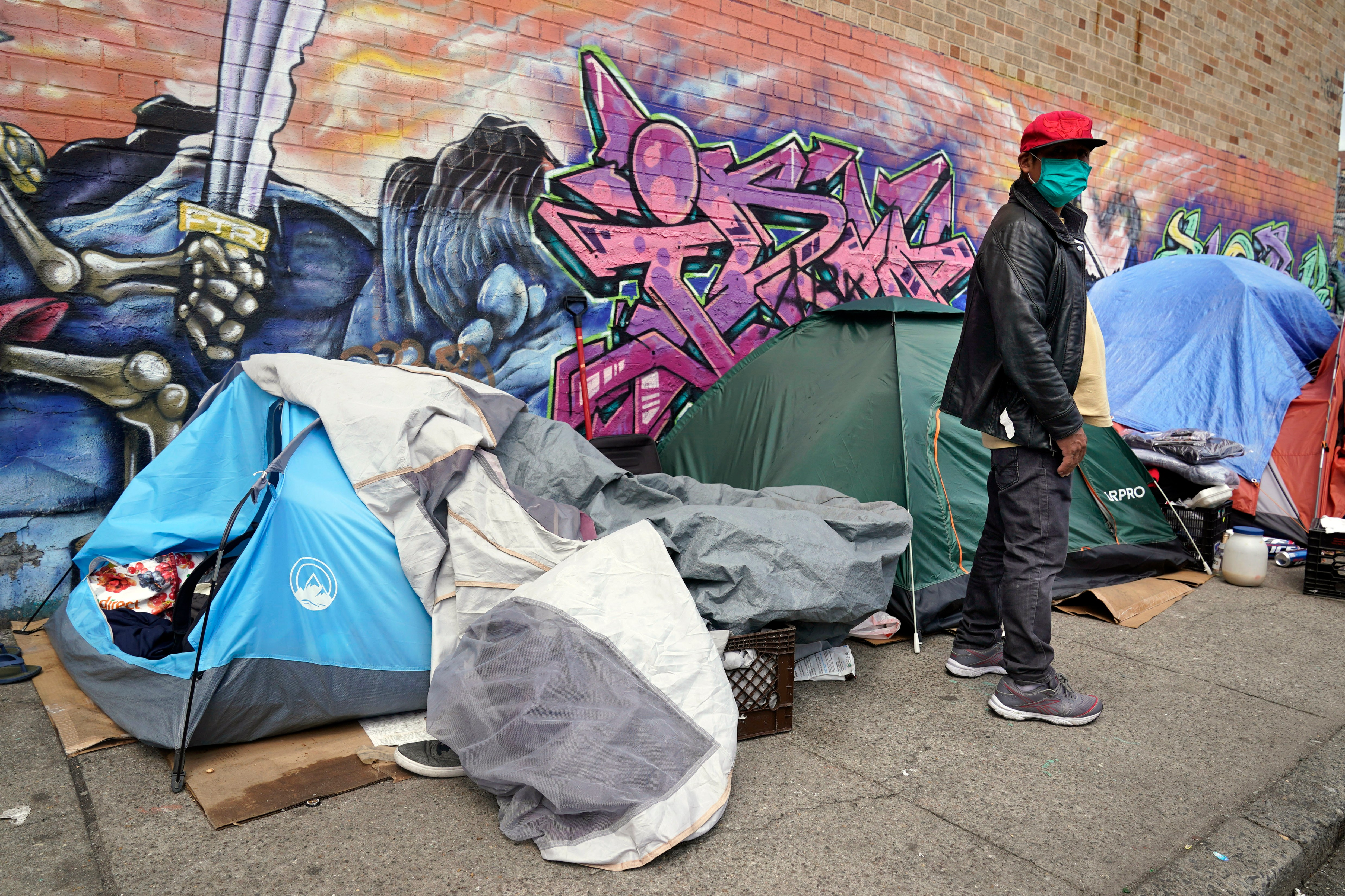 FILE - Sotero Cirilo stands near the tent where he sleeps next to other homeless people in the Queens borough of New York on April 14, 2021. The City Council unanimously approved a “Homeless Bill of Rights” in April 2023 that would make New York the first big U.S. city to establish an explicit right to sleep in at least some public places. If Mayor Eric Adams, a Democrat, allows the measure to become law, it could be a notable departure for the city — which has for years sent police and sanitation crews to clear homeless encampments as they arise. (AP Photo/Seth Wenig, File)