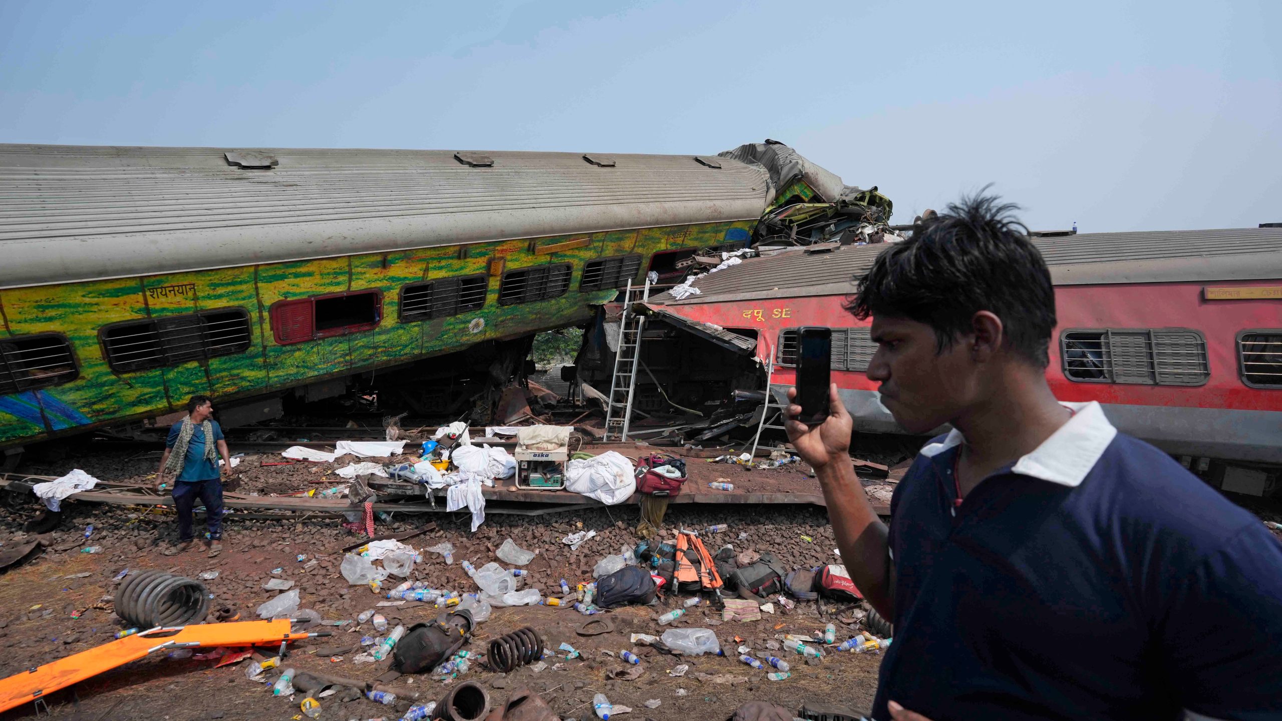 People inspect the site of passenger trains that derailed in Balasore district, in the eastern Indian state of Orissa, Saturday, June 3, 2023. Rescuers are wading through piles of debris and wreckage to pull out bodies and free people after two passenger trains derailed in India, killing more than 280 people and injuring hundreds as rail cars were flipped over and mangled in one of the country’s deadliest train crashes in decades. (AP Photo/Rafiq Maqbool)