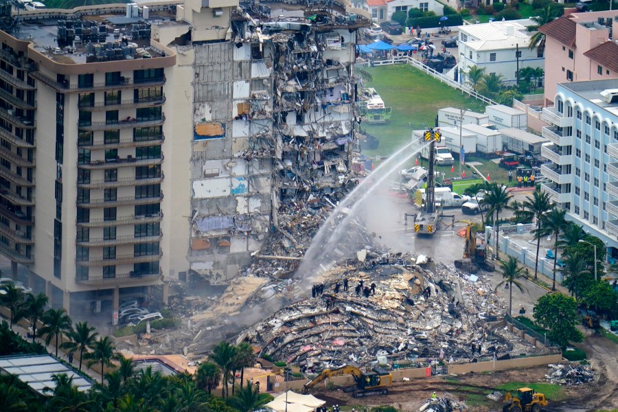 FILE - Rescue personnel work at the remains of the Champlain Towers South condo building, June 25, 2021, in Surfside, Fla. The swimming pool deck of the beachfront South Florida condominium where 98 people died when the building collapsed two years ago failed to comply with the original codes and standards, with many areas of severe strength deficiency, federal investigators said Thursday, June 15, 2023. (AP Photo/Gerald Herbert, File)