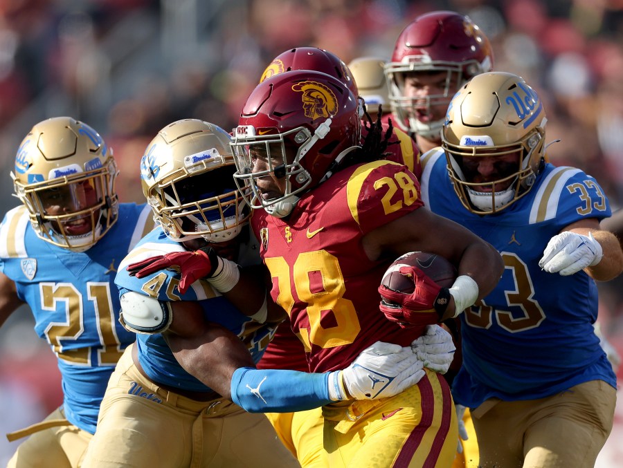 Keaontay Ingram of the USC Trojans rushes the ball as he is met by Mitchell Agude of the UCLA Bruins during the first quarter at Los Angeles Memorial Coliseum on Nov. 20, 2021 in Los Angeles. (Harry How/Getty Images)