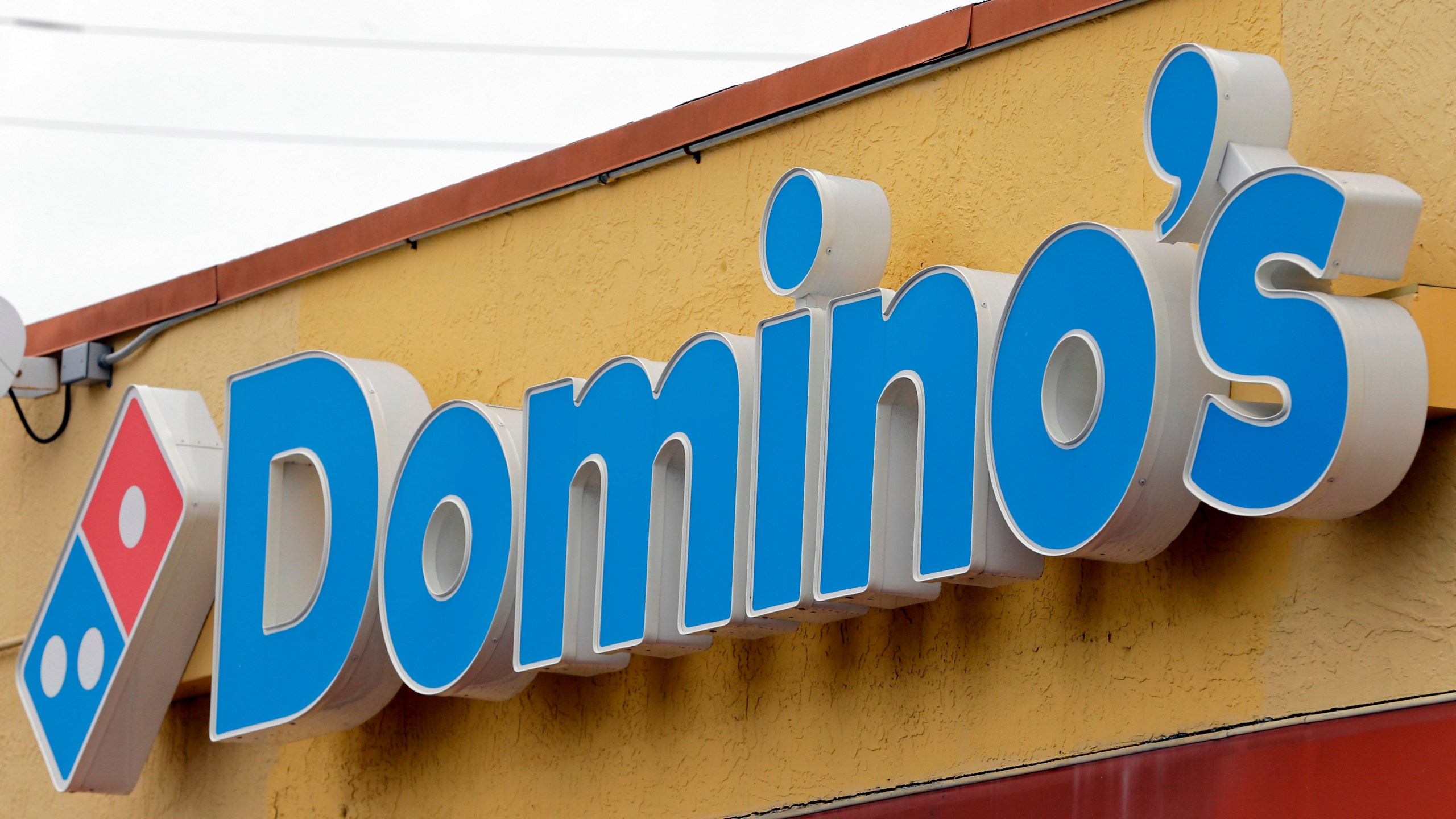 FILE- A Domino's Pizza sign hangs above a location in Hialeah, Fla., Oct. 27, 2016. Domino’s Pizza said Wednesday, July 12, 2023, it is partnering with Uber Eats to make deliveries in the U.S. and 27 international markets. (AP Photo/Alan Diaz, File)