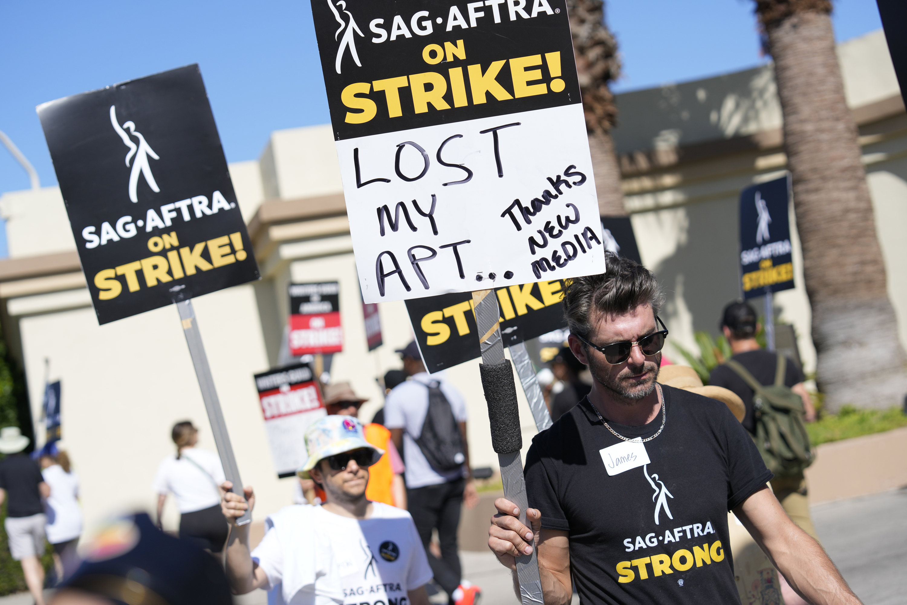 SAG-AFTRA member James Hutson carries a picket sign outside Paramount studios on Wednesday, July 19, 2023, in Los Angeles. The actors strike comes more than two months after screenwriters began striking in their bid to get better pay and working conditions. (AP Photo/Chris Pizzello)