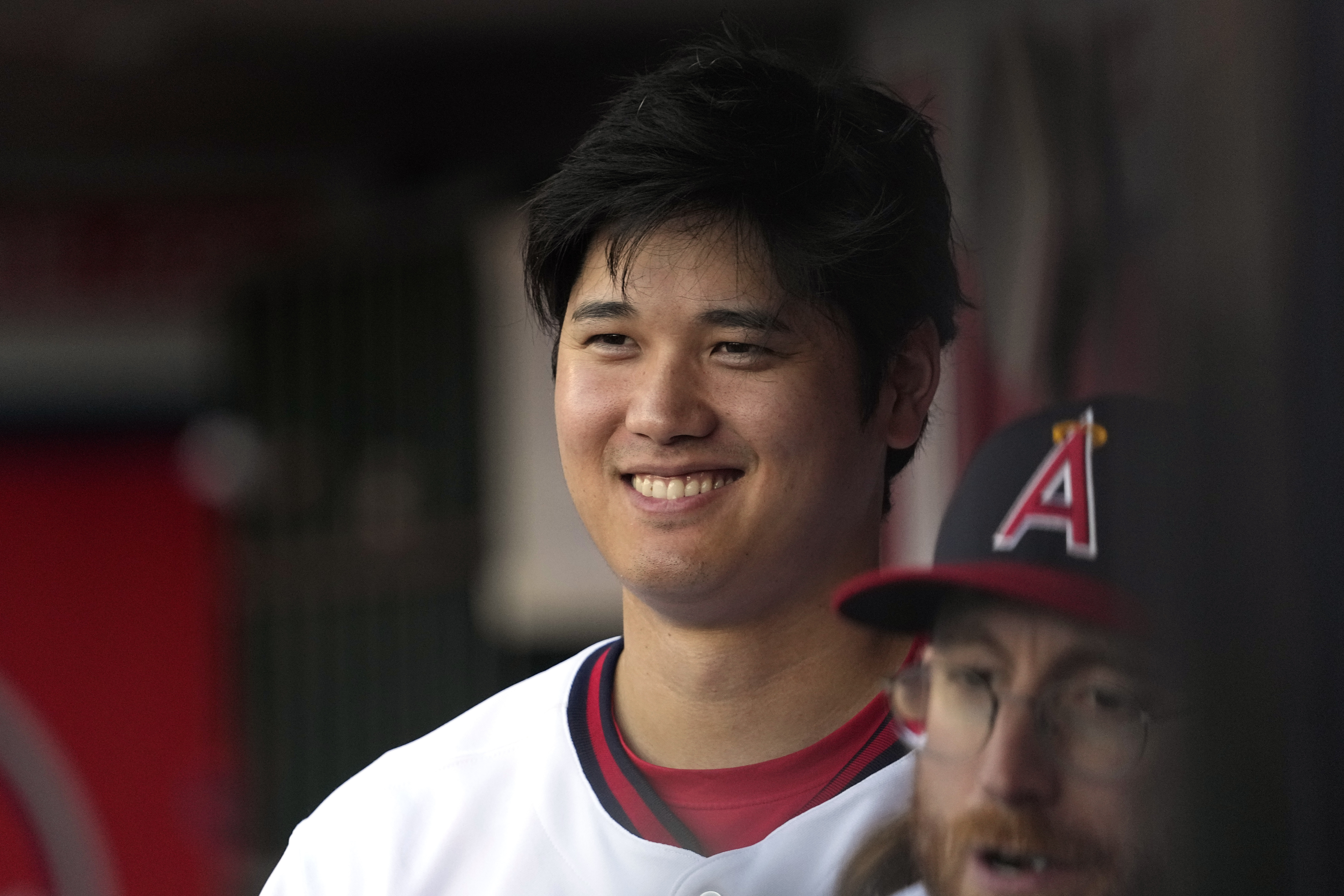 Los Angeles Angels' Shohei Ohtani smiles as he stands in the dugout prior to a baseball game against the Pittsburgh Pirates Saturday, July 22, 2023, in Anaheim, Calif. (AP Photo/Mark J. Terrill)