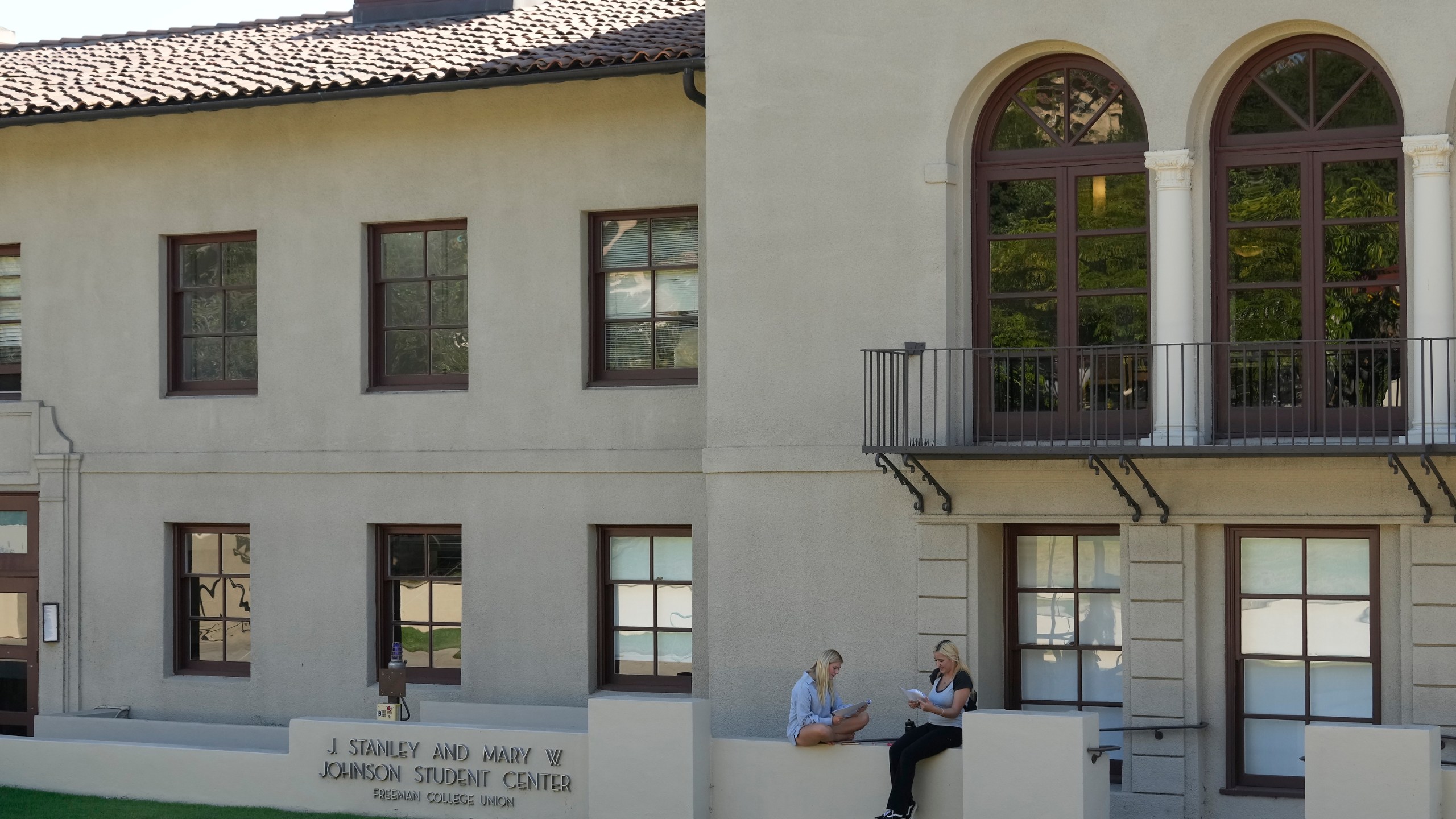 Students sit outside the Freeman College Union building at Occidental College campus in Los Angeles, Thursday, July 27, 2023. Occidental College is the latest school to end legacy admissions in the wake of a Supreme Court decision removing race from admissions decisions. (AP Photo/Damian Dovarganes)