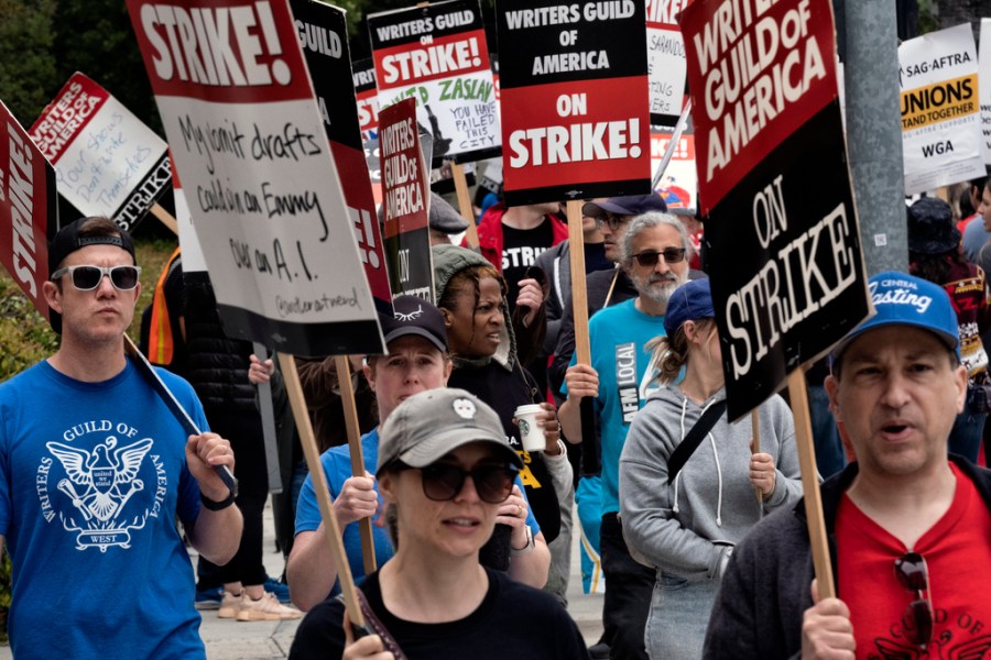 Picketers pass near a studio entrance during a Writers Guild rally.