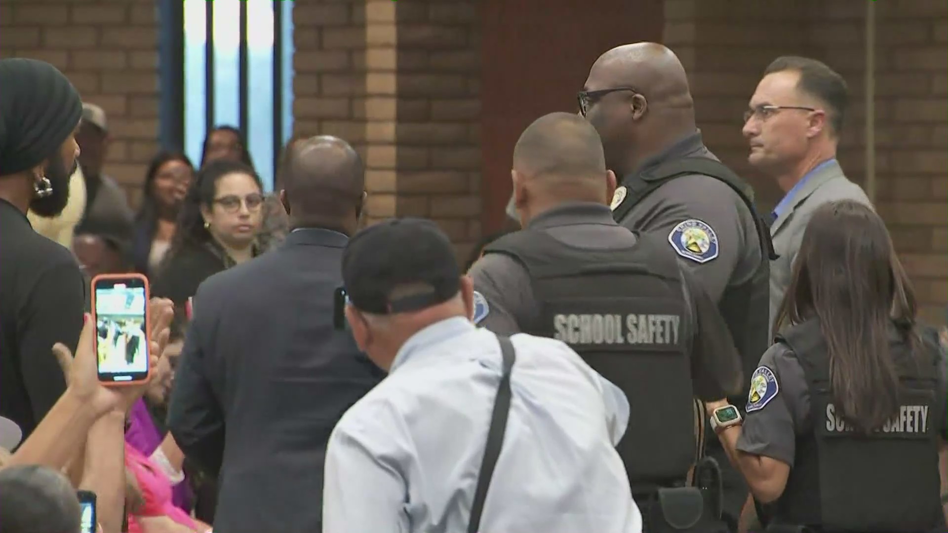 Tony Thurmond, State Superintendent of Public Instruction, escorted outside after he spoke against the policy at a board meeting with the Chino Valley Unified School District on July 20, 2023. (KTLA)