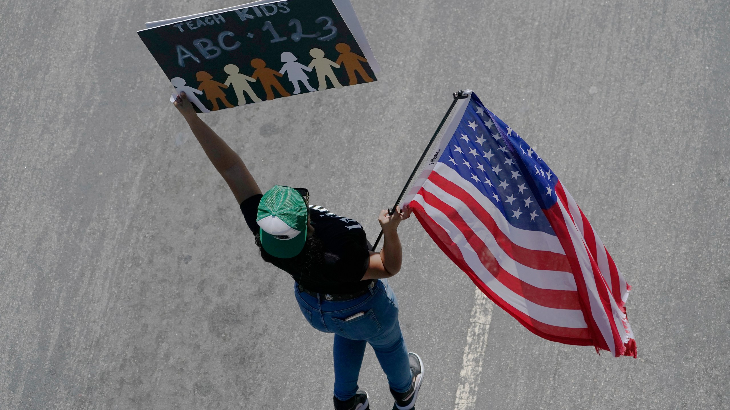 A demonstrator with the Leave our Children Alone holds a sign during a Parents Rights group march on Third St., downtown to Los Angeles Unified School District headquarters on Tuesday, Aug. 22, 2023. (AP Photo/Damian Dovarganes)