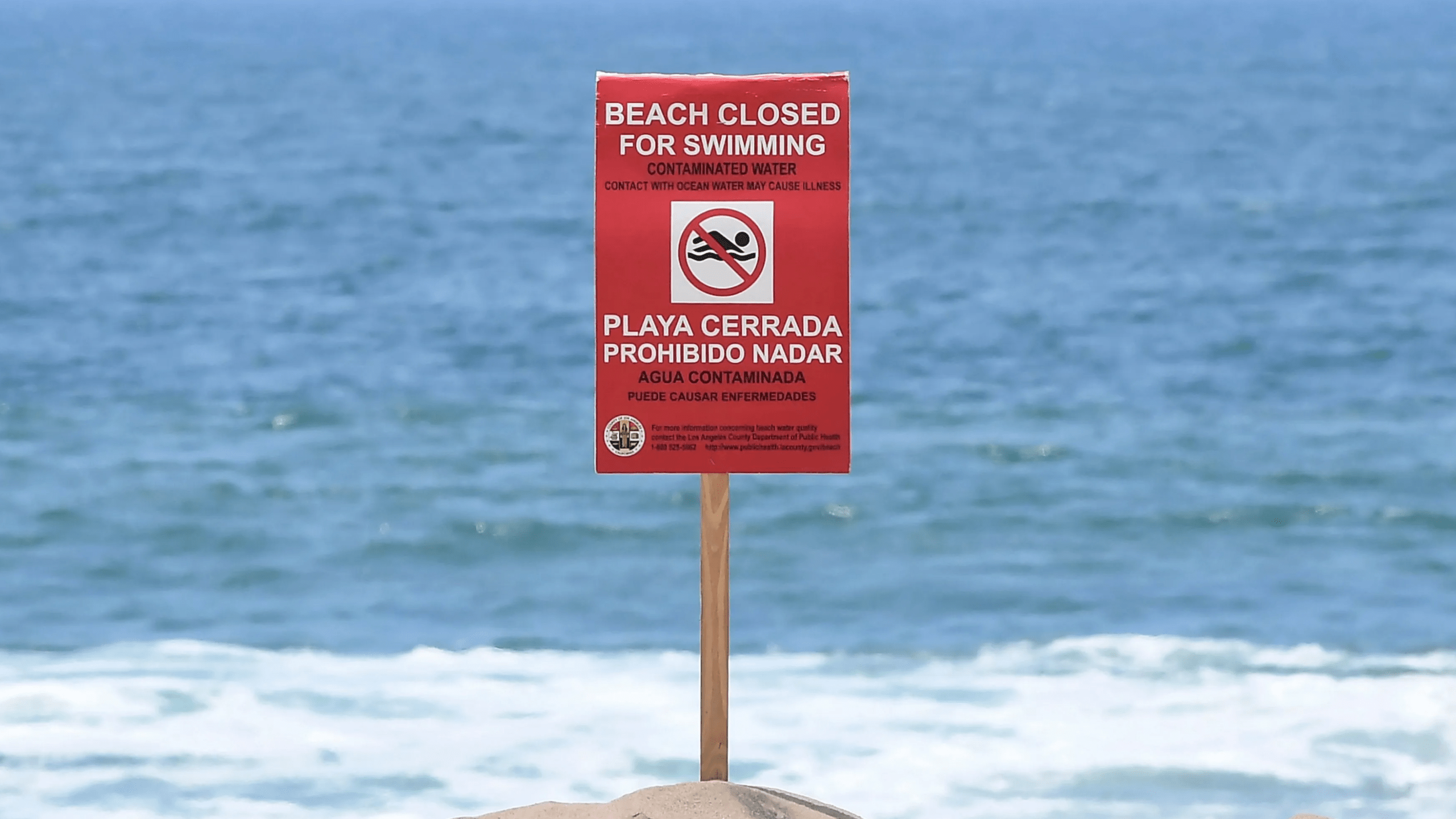 A sign indicates beach in Los Angeles County is closed to the public for swimming on July 13, 2021. (FREDERIC J. BROWN/AFP via Getty Images)